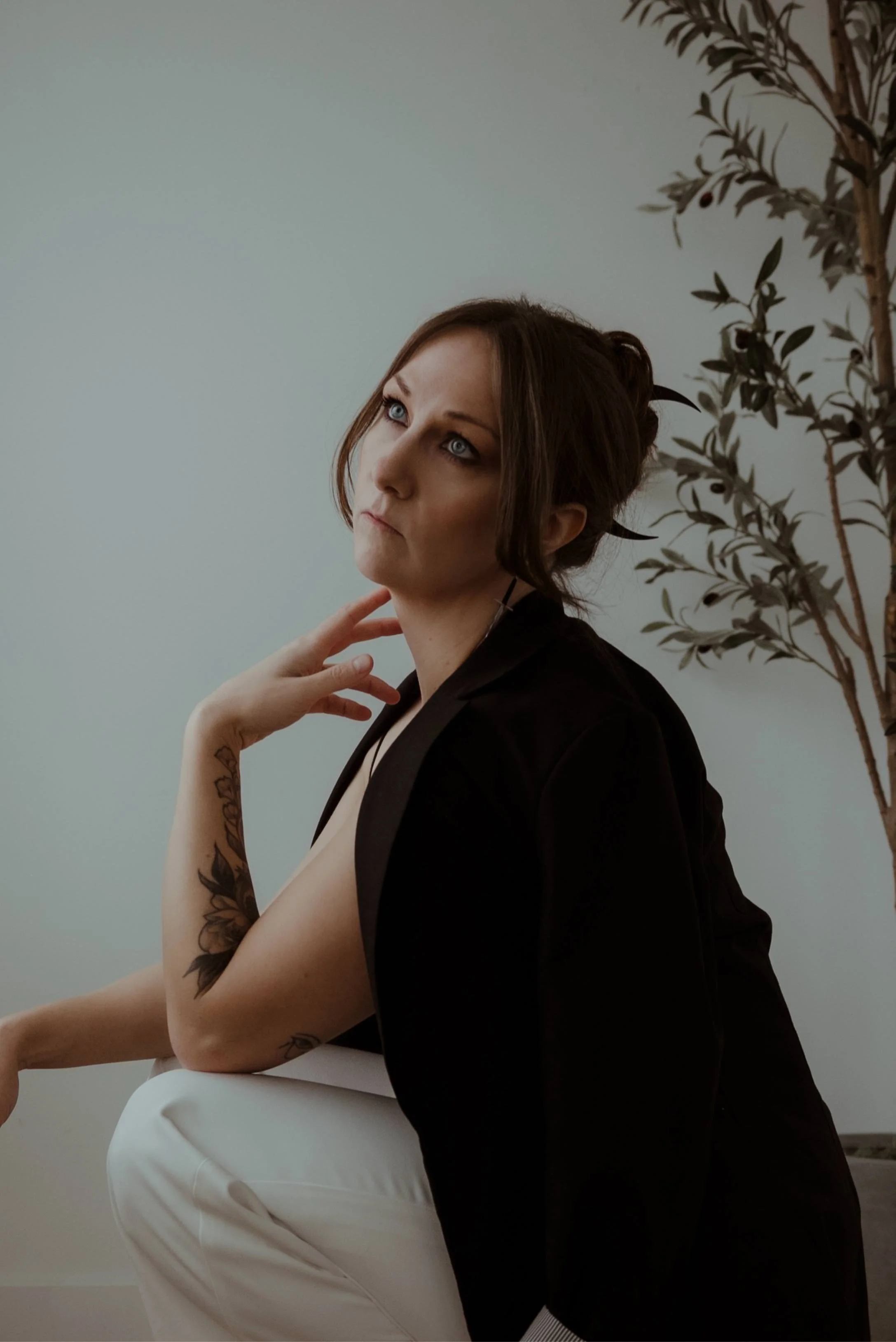 Portrait of Canadian dark fantasy romance author Kaitlyn L. Hill, a moody yet professional image in a clean white studio.