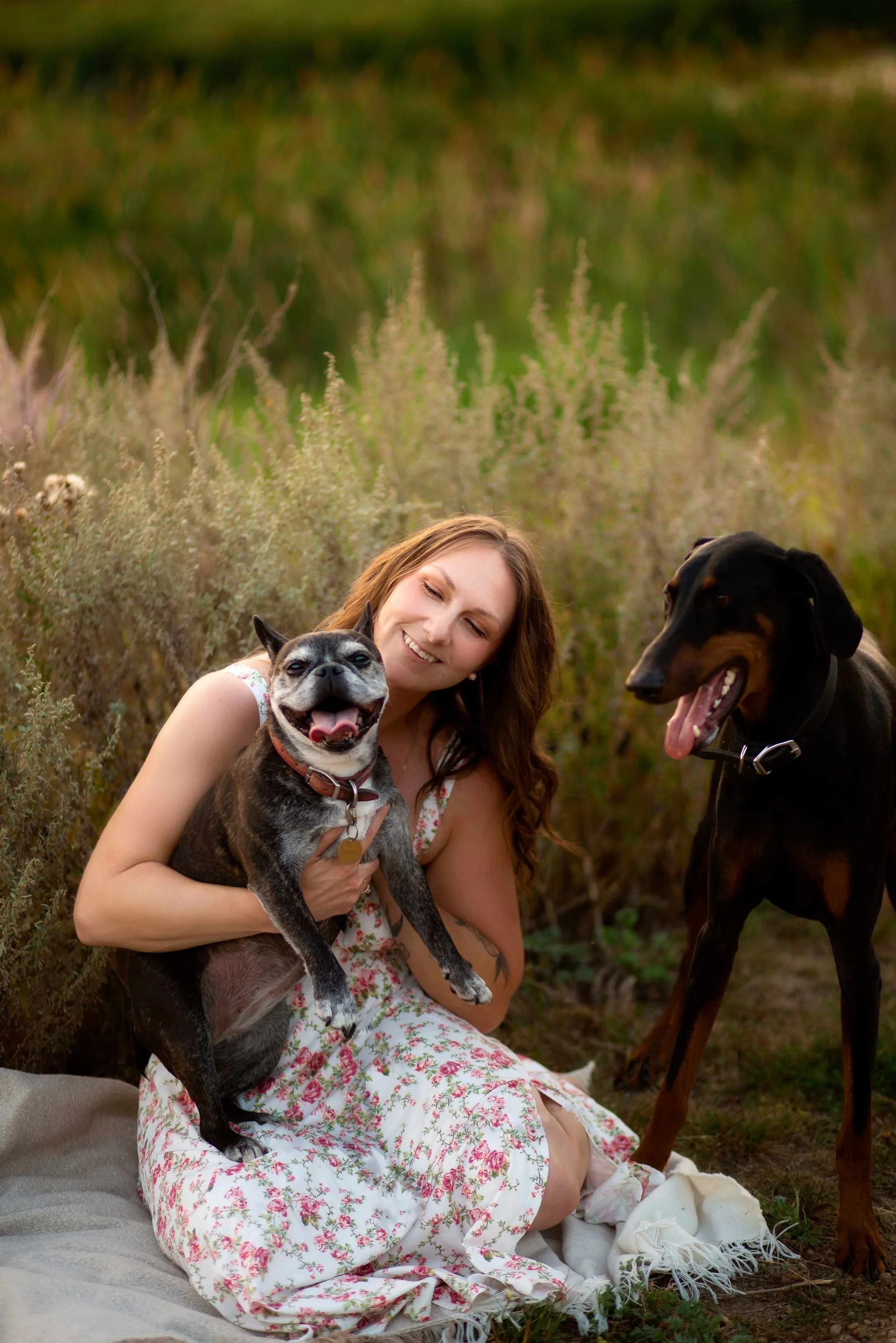 Author, Kaitlyn L. Hill, with her two dogs, Molly and Hades, in a field in Alberta, Canada.