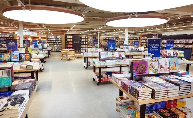 Large circular overhead lightboxes installed in a modern bookstore, providing soft, even illumination throughout the retail space.