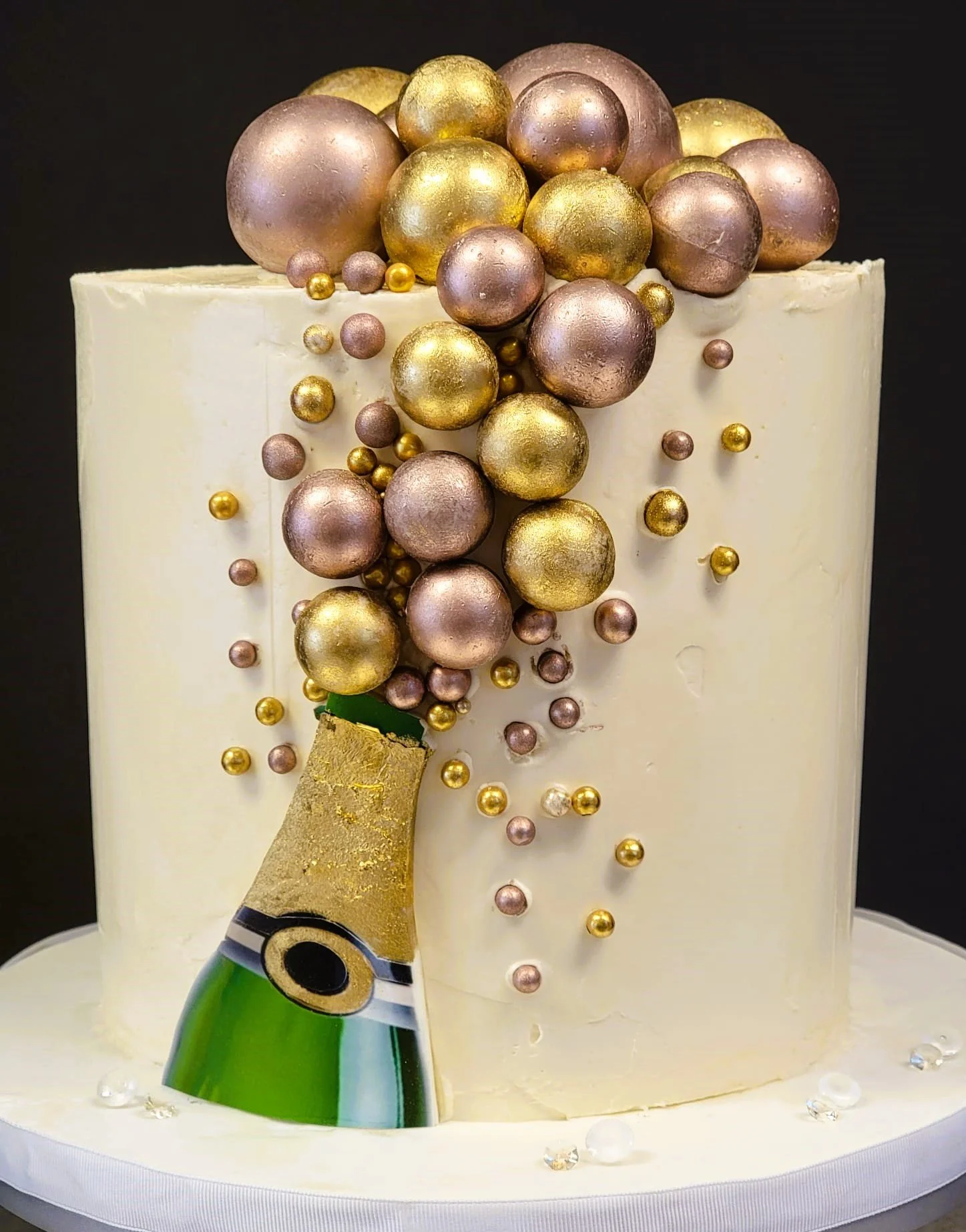 Birthday cake with a champagne bottle and many golden and pink bubbles floating