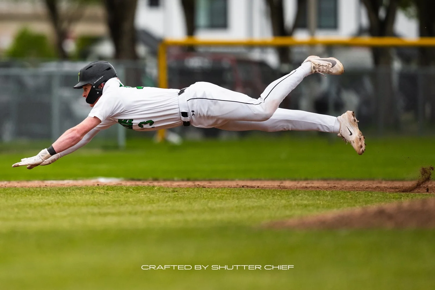 Baseball player diving across the grass for the ball