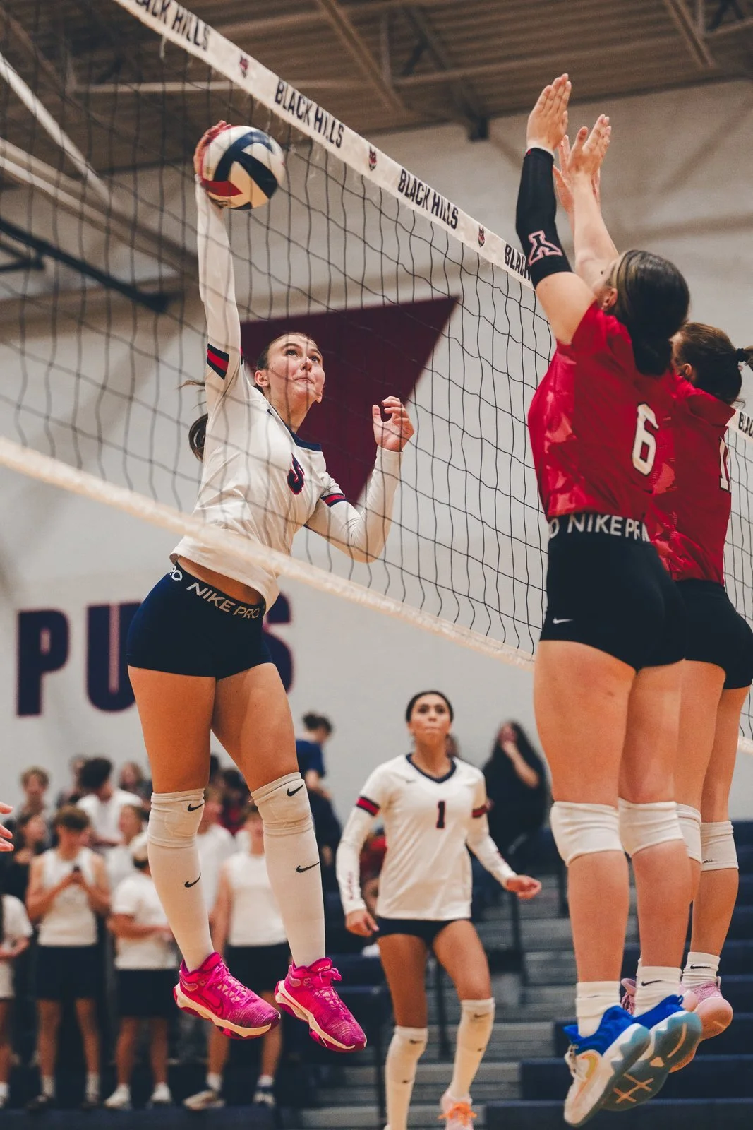 Volleyball player leaping at the net during a match