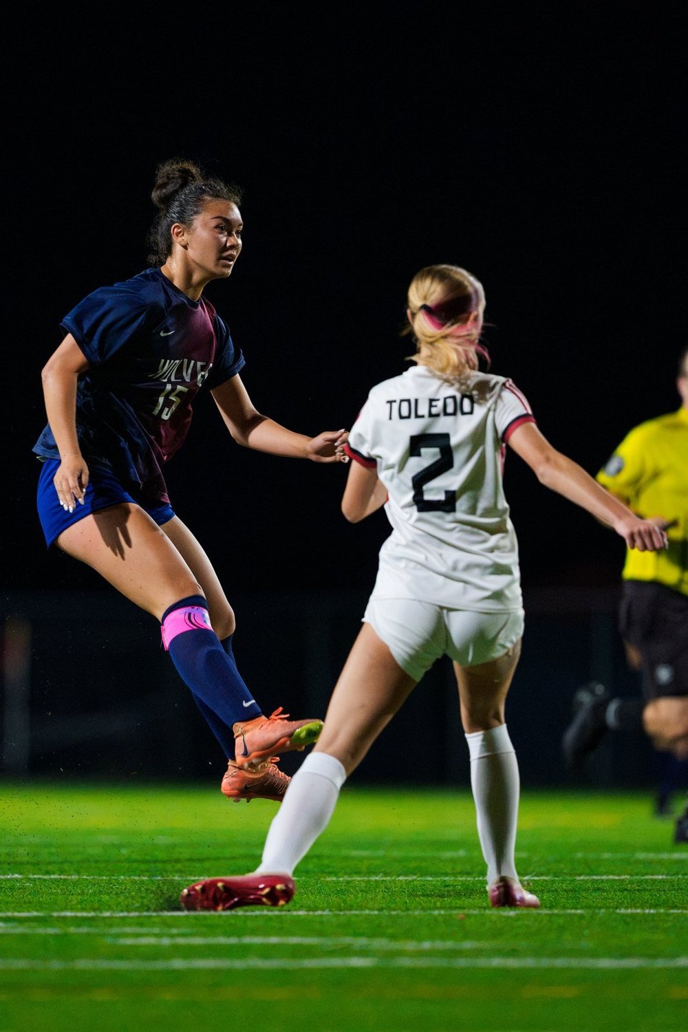 Soccer players contesting the ball under stadium lights