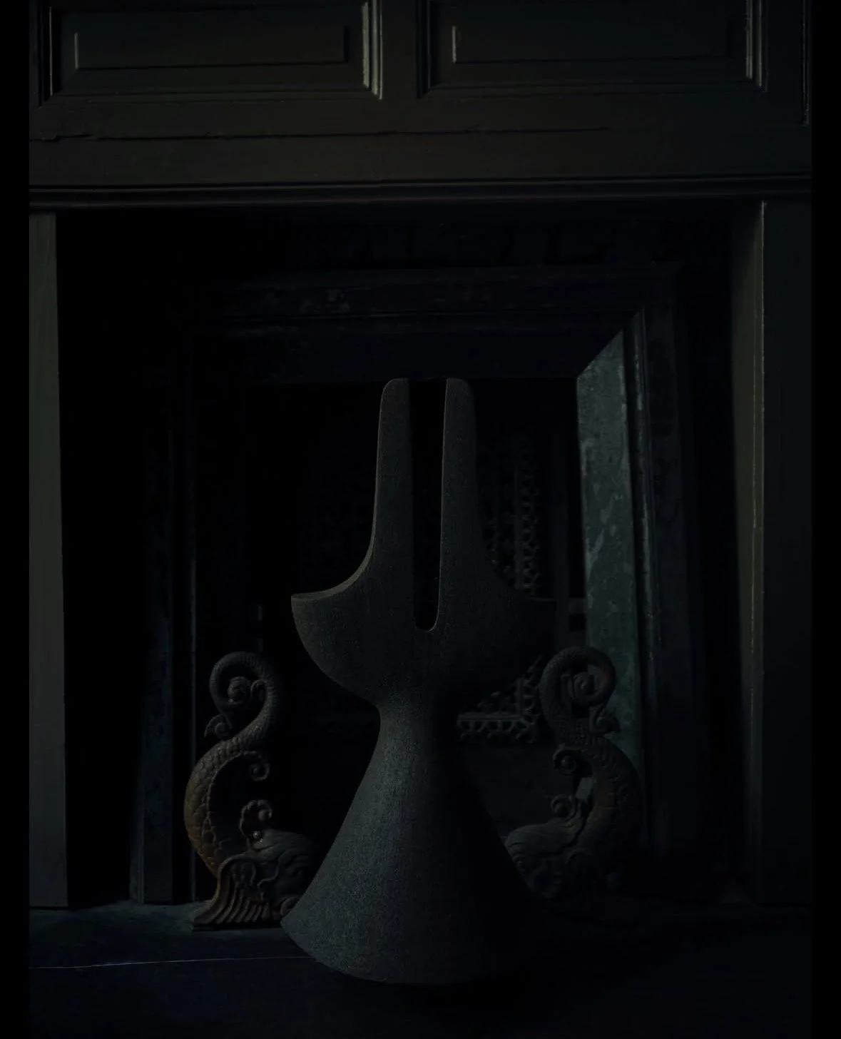 Dark fireplace with a decorative fire grate in front.