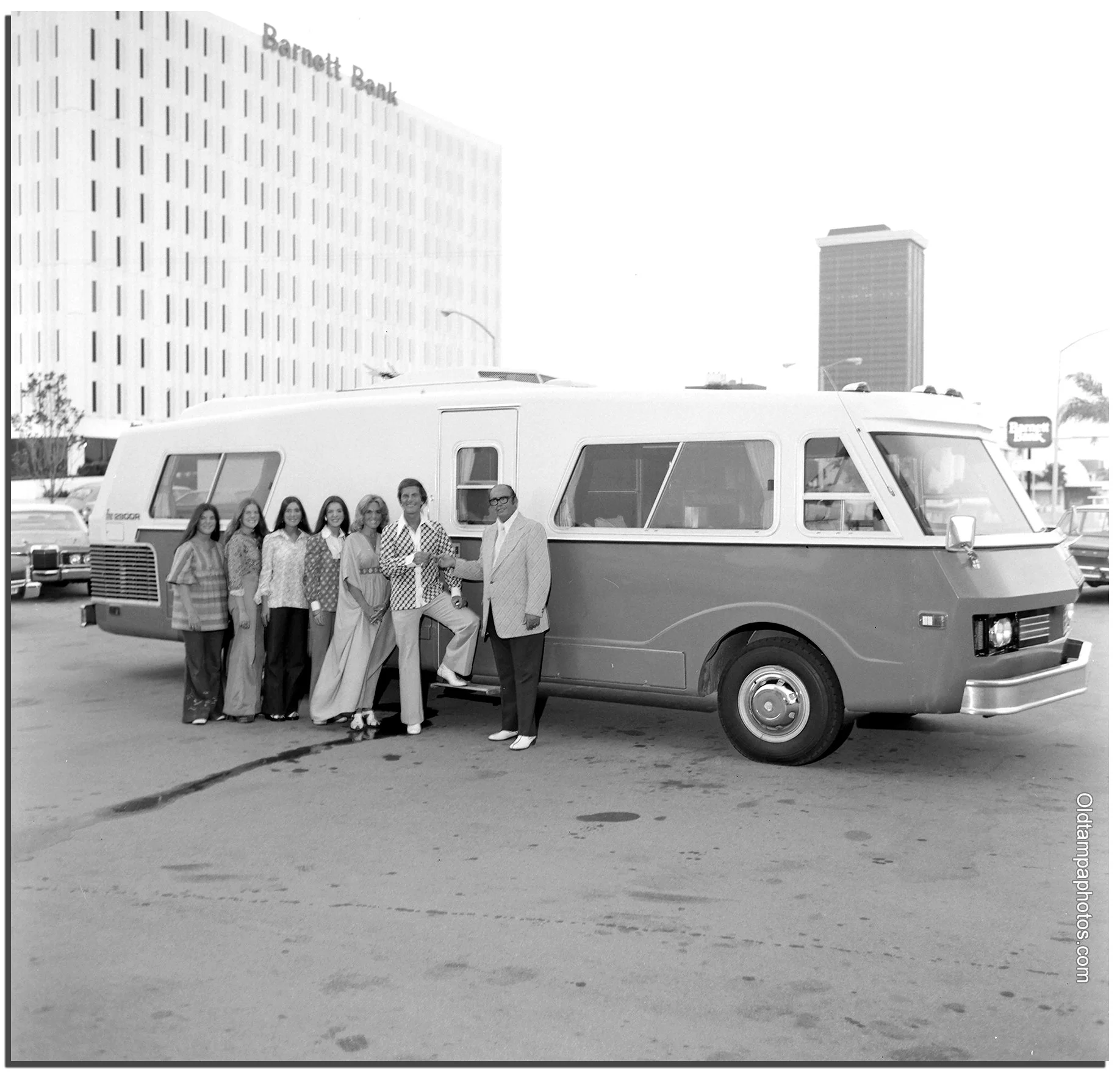 Singer Pat Boone and his family stand beside a newly purchased 1973 motorhome in downtown Tampa, Florida, with the Barnett Bank building visible in the background.