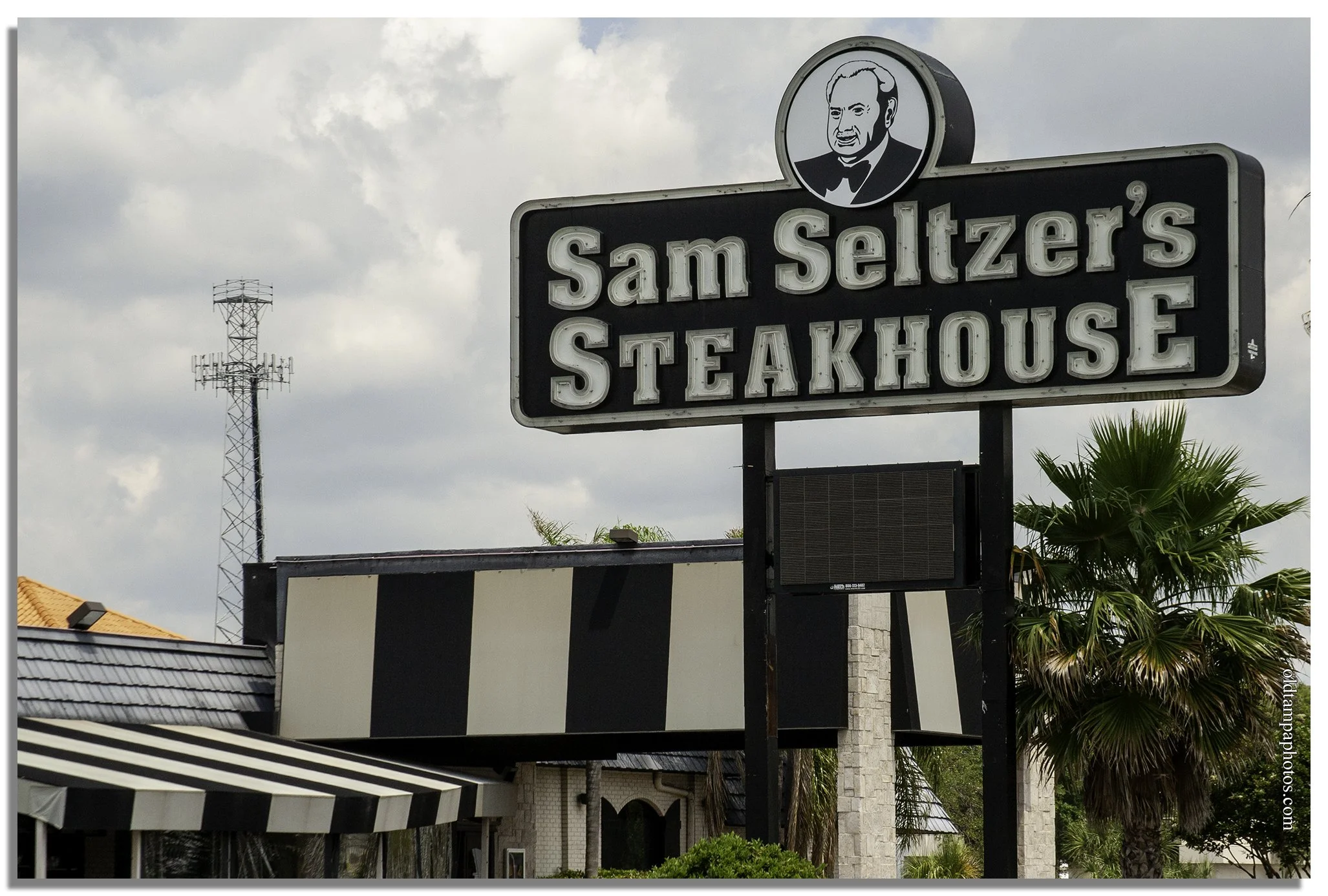 Sam Seltzer’s Steakhouse sign on North Dale Mabry Highway in Tampa, Florida. The popular steakhouse opened in 1995 and became a local landmark, known for affordable steaks, generous portions, and life-sized plastic cows outside the restaurant.