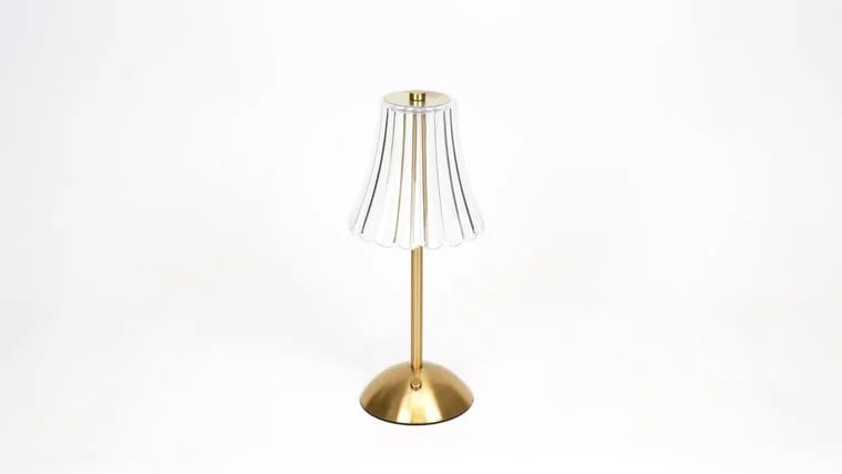 A gold table lamp with a white lampshade that has vertical gold stripes, set against a plain white background.