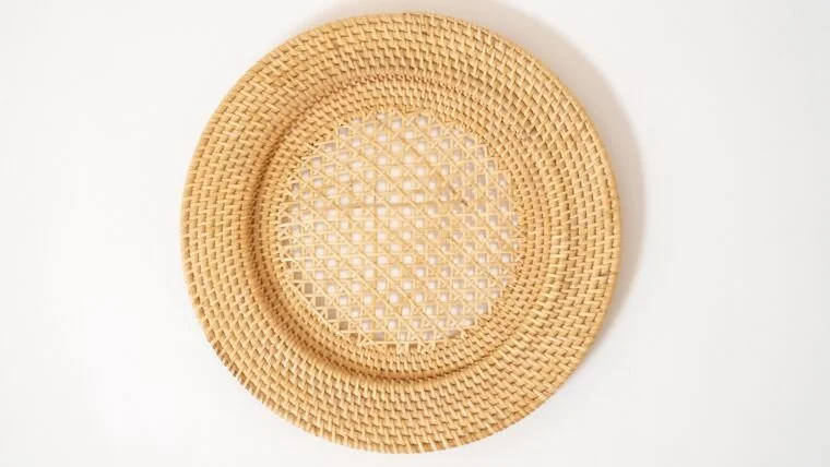 A light-colored straw or wicker hat placed on a plain white surface.