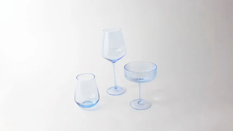 Three different types of empty glassware on a white surface with a plain white background.
