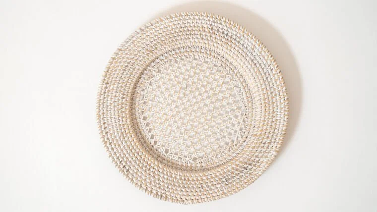 A woven circular mat or tray made of light-colored material on a white background.