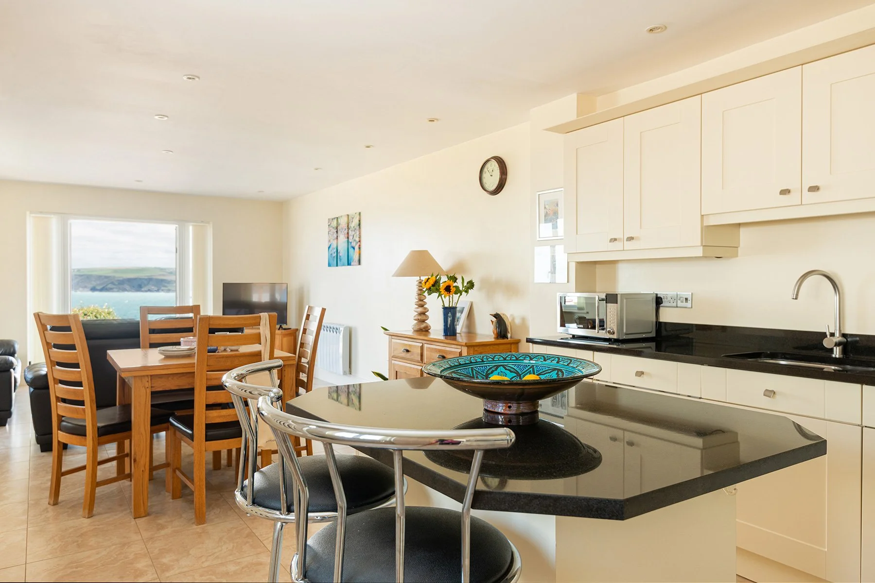 looking across the kitchen island through the lounge at sea gems to the sea views out the patio doors