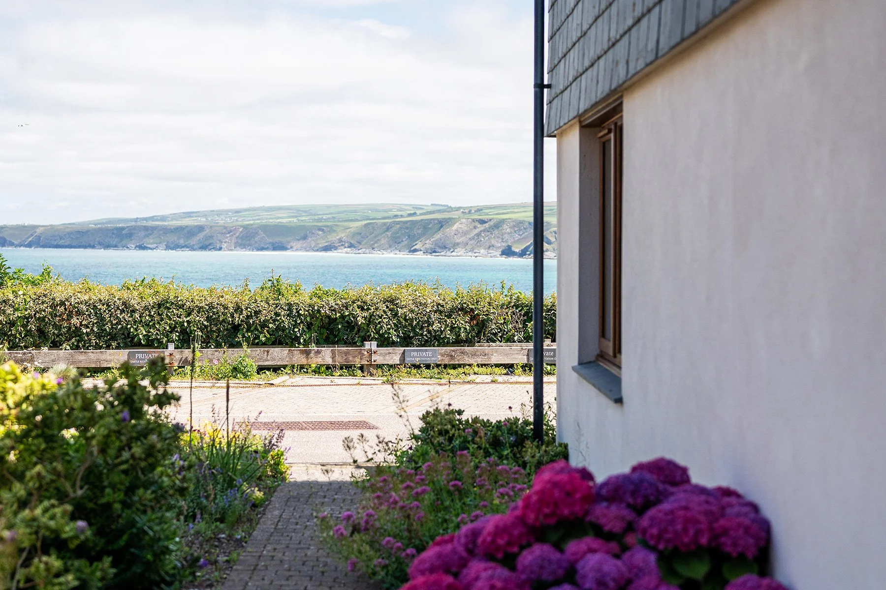 looking along the side of sea gems to the sea views across port isaac bay in cornwall