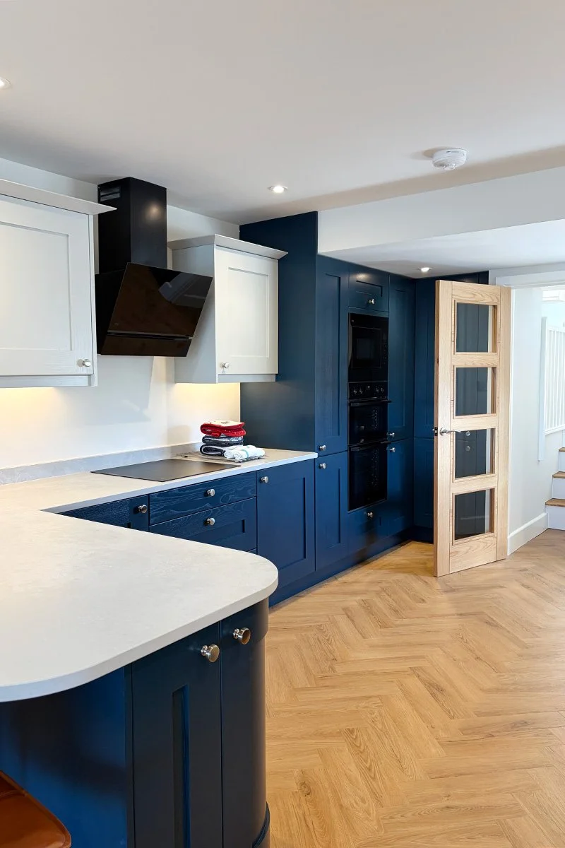 modern navy blue kitchen with herringbone flooring at pebblestones self catering holiday accommodation in port isaac, cornwall