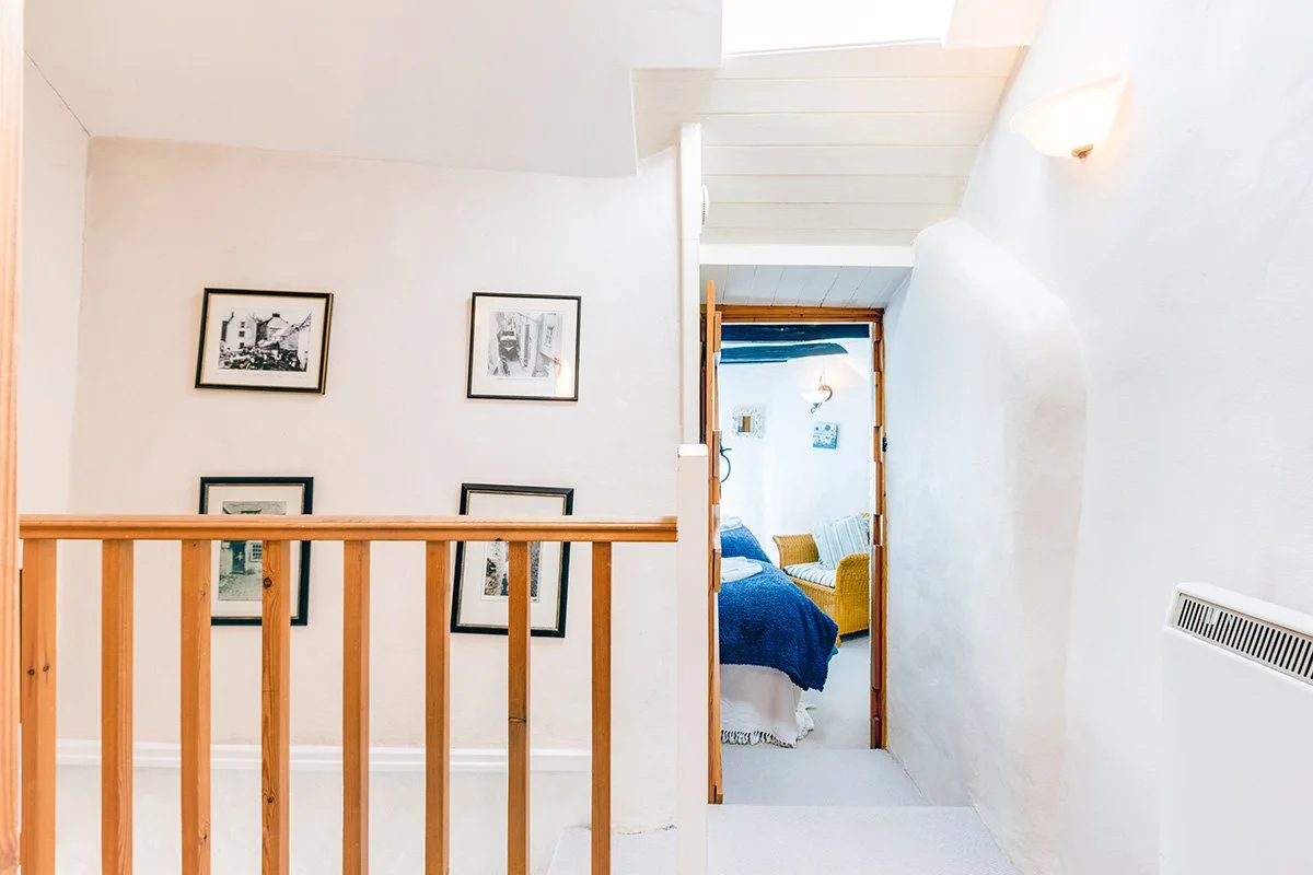 upstairs landing of temple cottage with historic photographs of port isaac