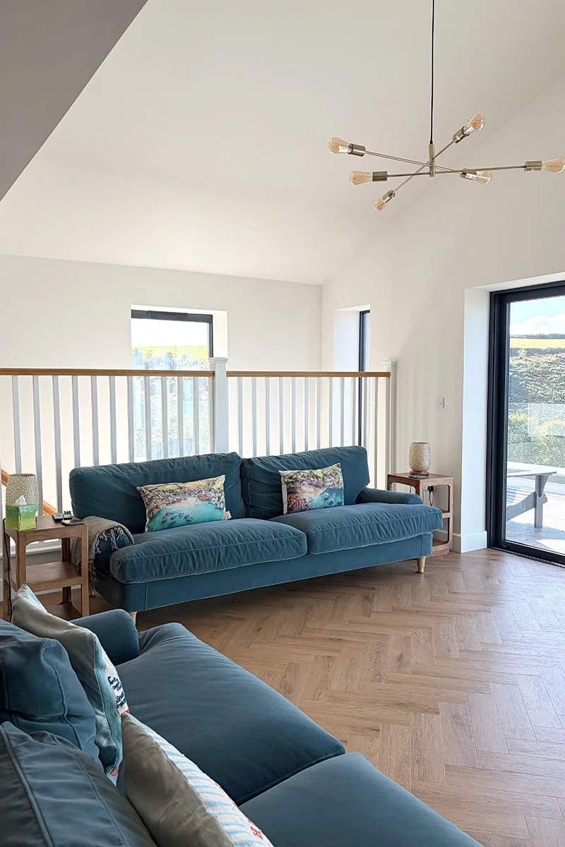 lounge with full height ceiling and views over port isaac at pebblestones in port isaac, cornwall