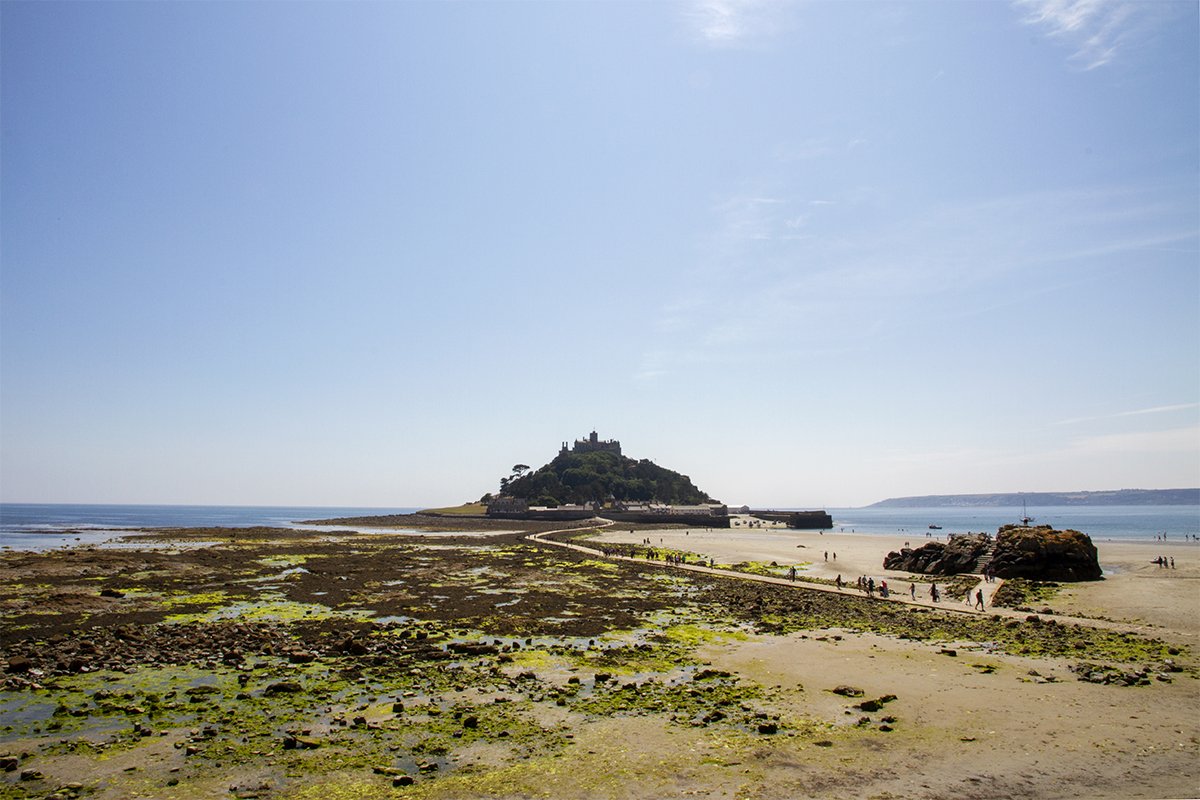 st michaels mount at low tide showing people walking across the causeway