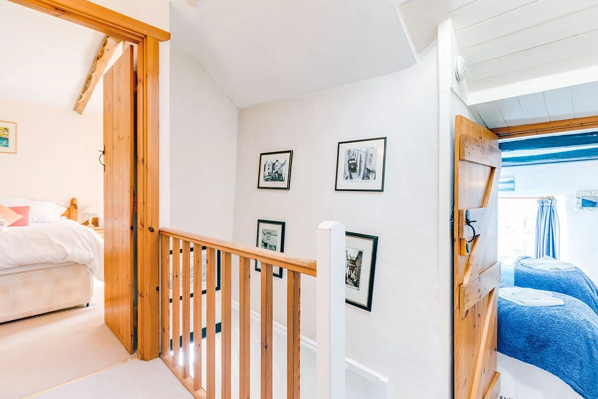 upstairs landing of temple cottage with historic photographs of port isaac