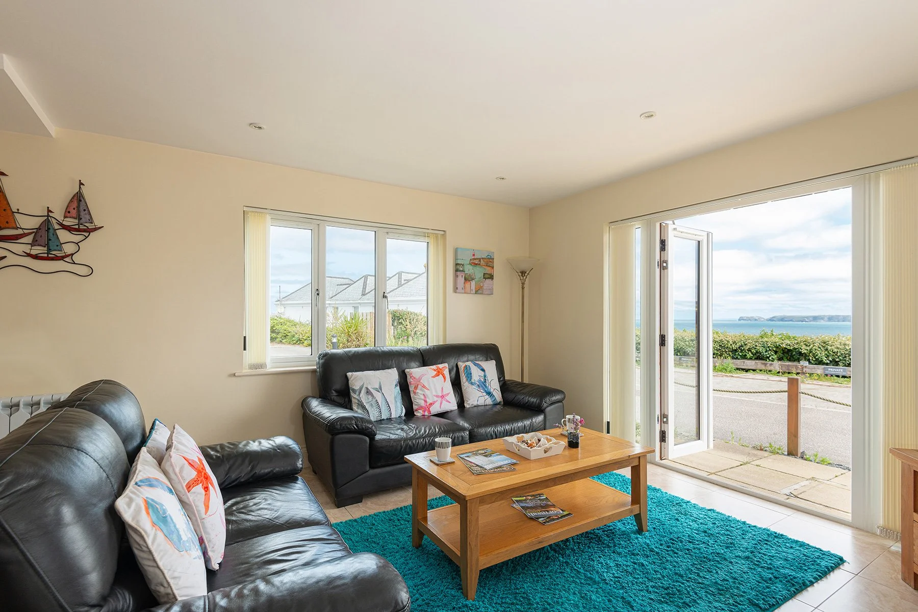 the lounge at sea gems in port isaac showing the sea views out of the patio doors