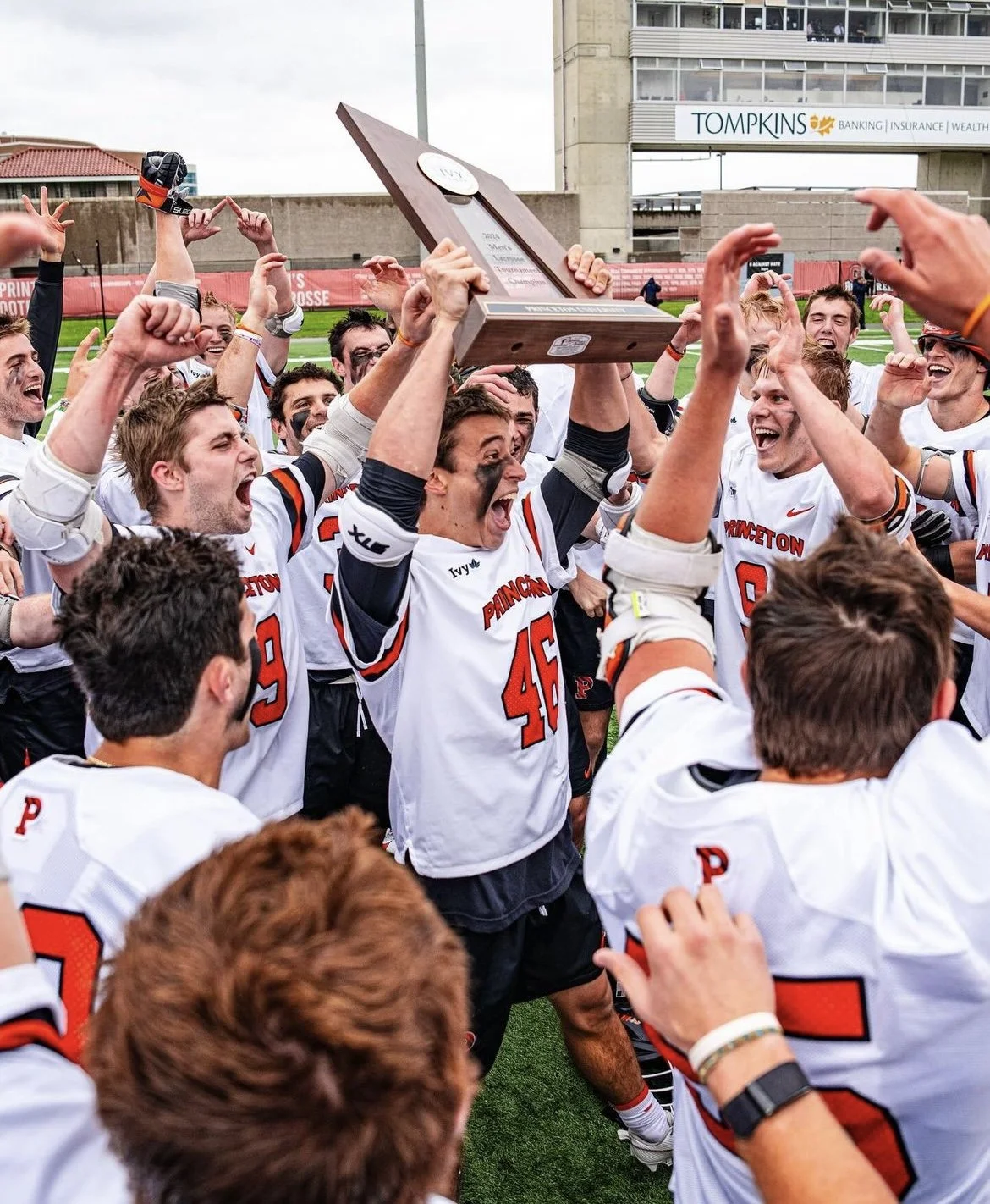 Football team celebrating victory, lifting trophy on the field.