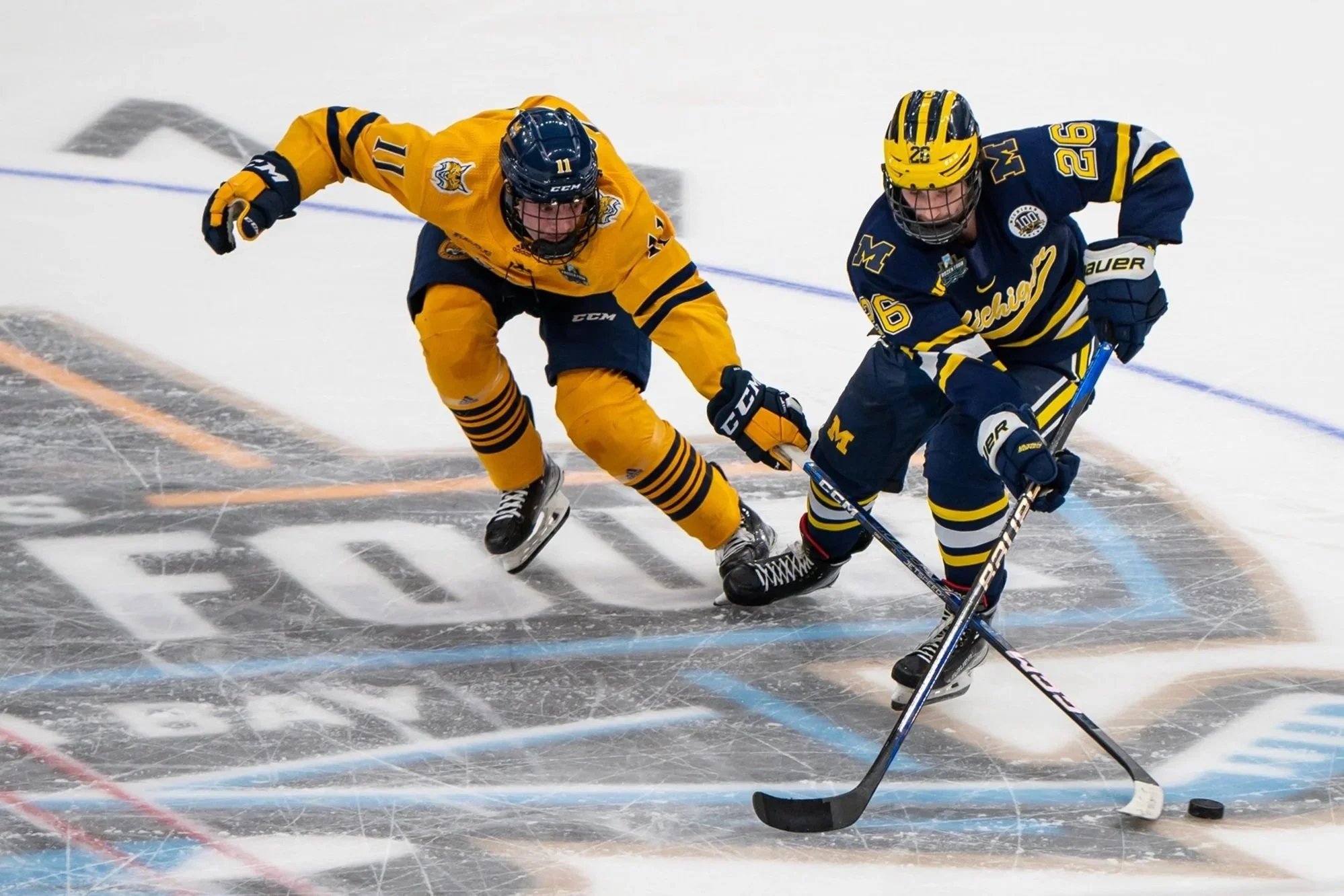 Michigan defenseman Seamus Casey (26) and Quinnipiac forward Collin Graf (11) battle for the puck during the second period of an NCAA semifinal game in the Frozen Four college hockey tournament Thursday, April 6, 2023, in Tampa, Fla. Kate Hua/The Mic