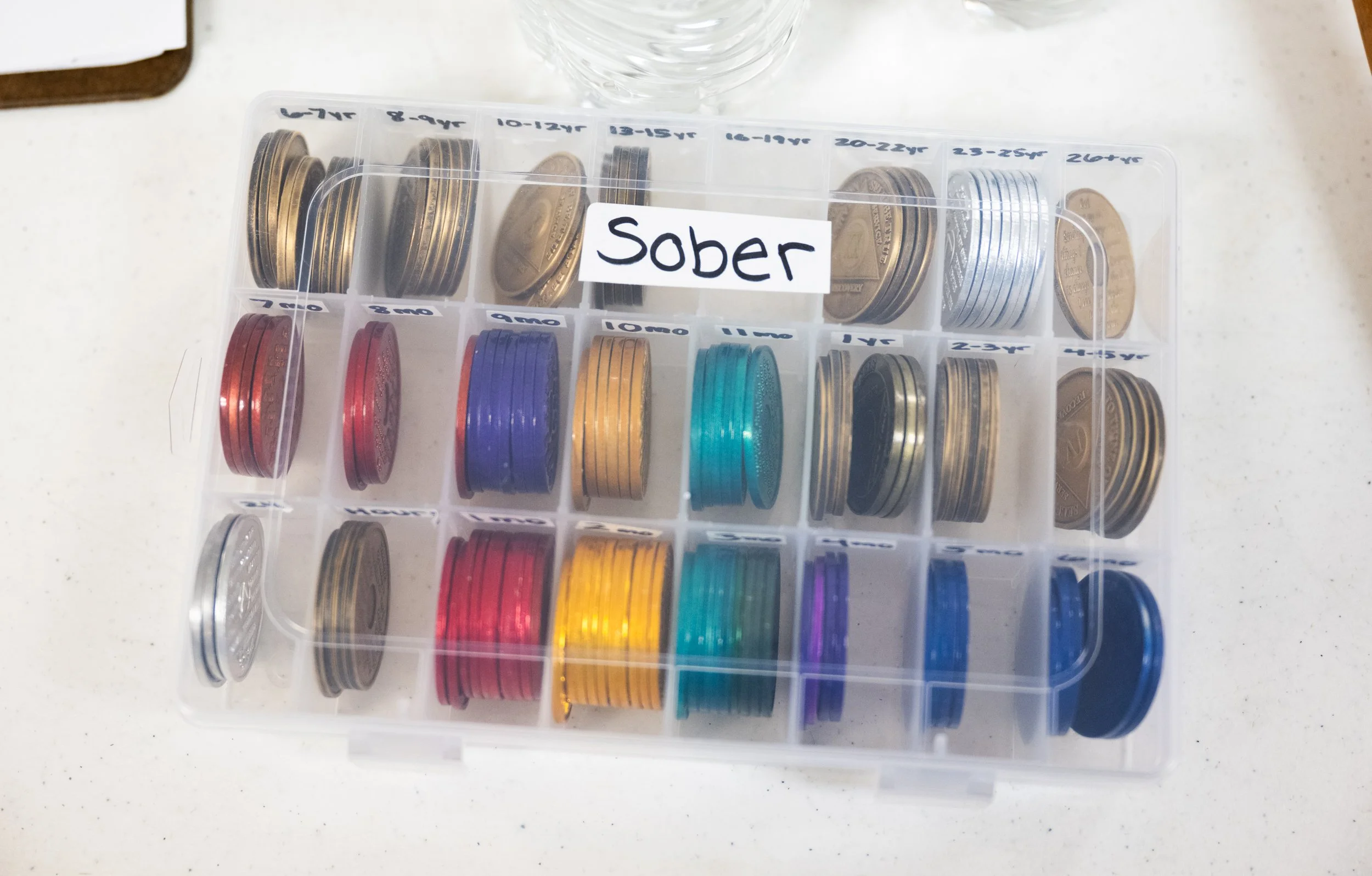 The container for sobriety chips at an AA meeting on March 17, 2026. Chips are given on important sobriety dates/times to group members or those who attend a meeting.