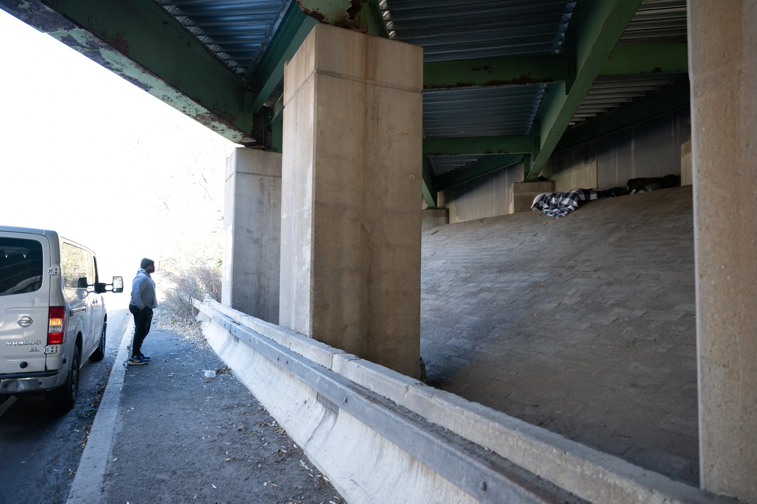 Andre Clark, a street outreach worker at PCHO, checks to see if an unhoused man is at a reported sleeping site under an underpass in Greece, N.Y. on Nov. 24, 2025. Clark states that it’s not uncommon for people to leave their sleeping arrangements du