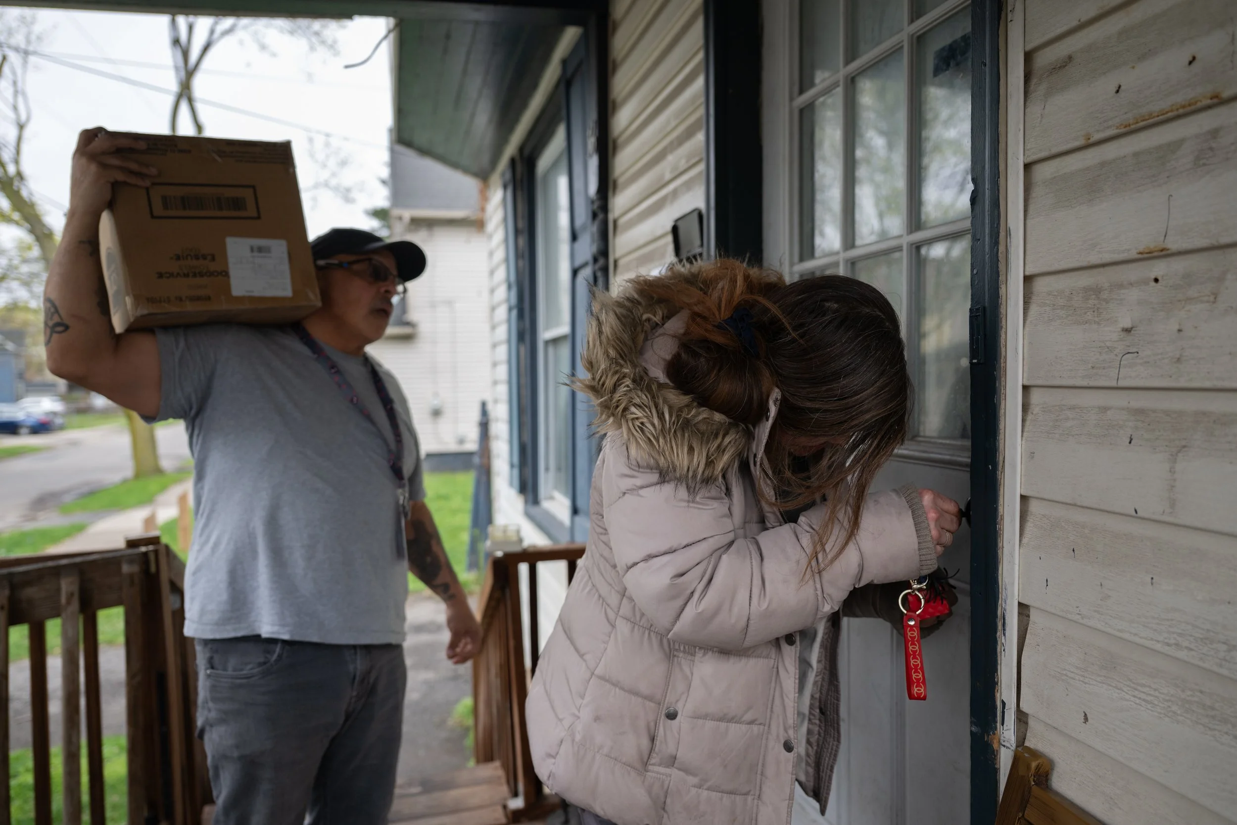 Stephen Rosa waits for Robin Carpenter to unlock her front door so that he can help carry in her belongings on April 17, 2026.