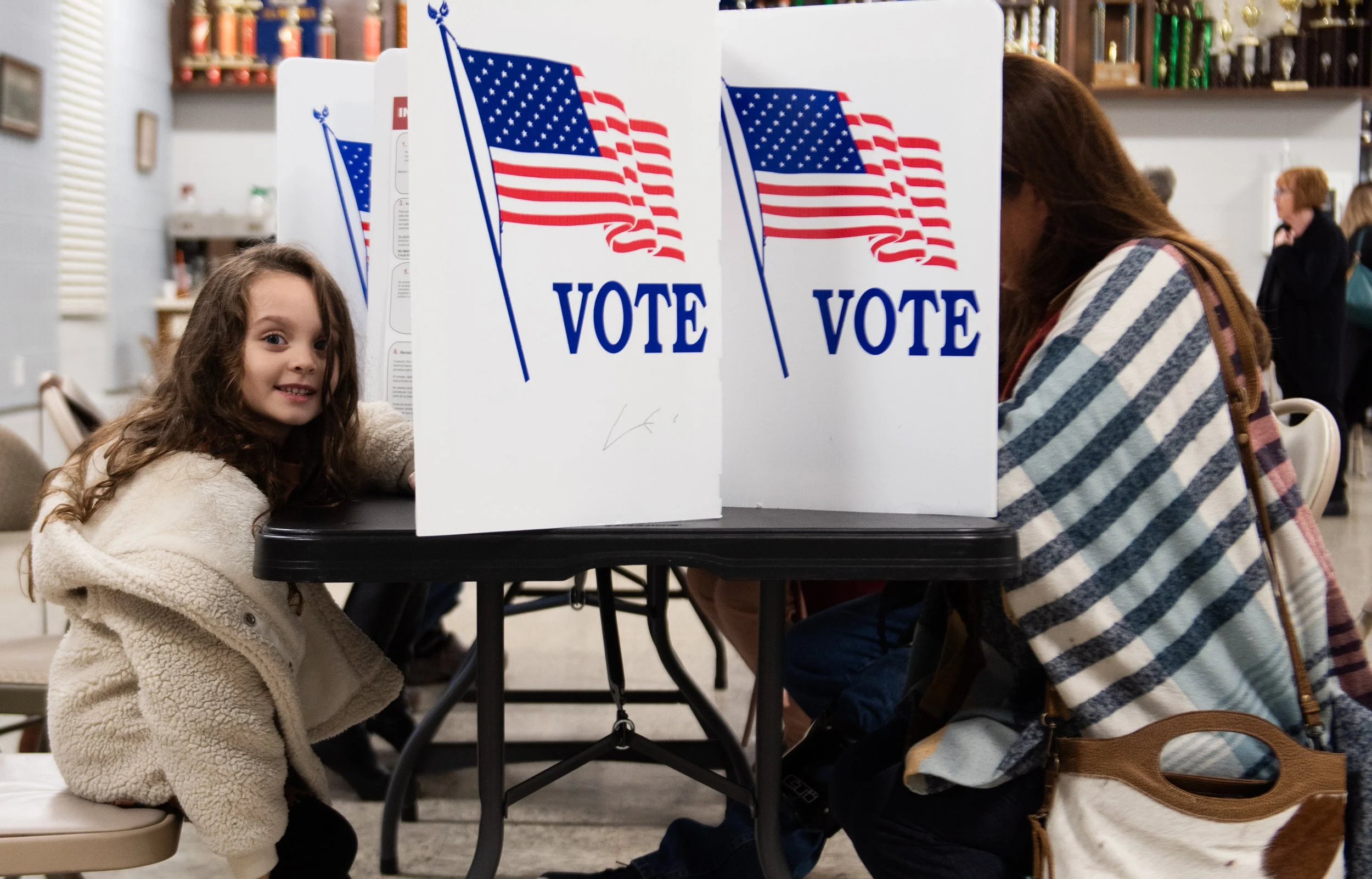 A child waits for their parent at a voting booth at the Henrietta Fire Company No. 1 in Henrietta, N.Y., Nov. 8, 2022. While the child’s parent requested to withhold their information, she told me that, “[she believes] that getting them excited about