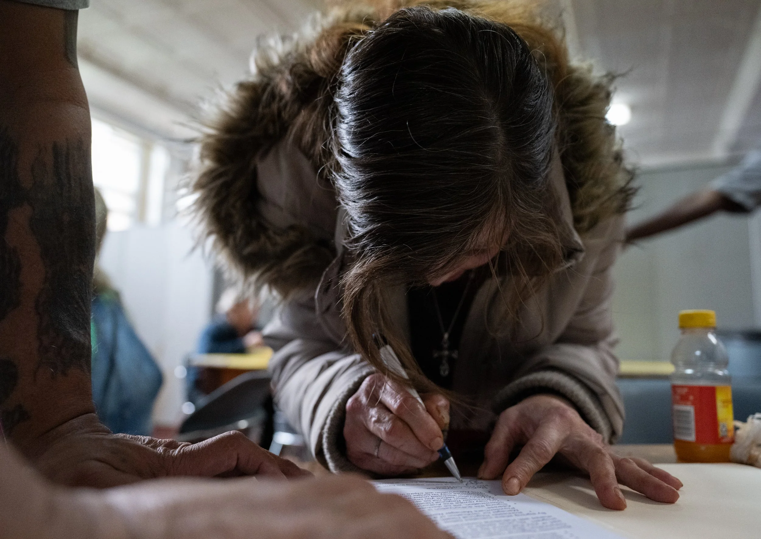 Robin Carpenter meets with Stephen Rosa to fill out PCHO paperwork at St. Peter's Kitchen on April 17, 2026. Carpenter has burns on 70% of her body from an episode over a decade ago. During that time, she was going through a dual schizophrenic episod