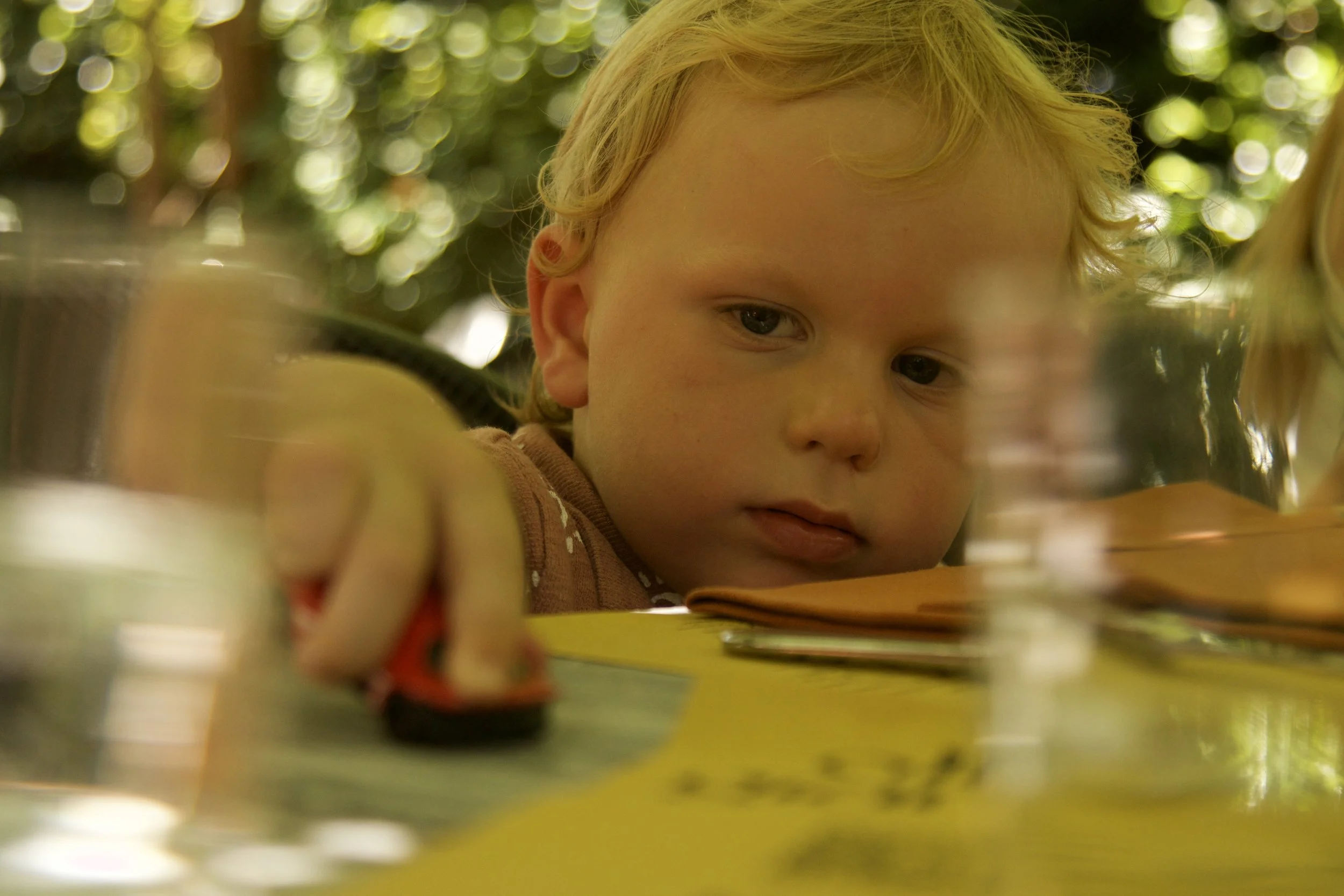 photograph of child playing with toy car