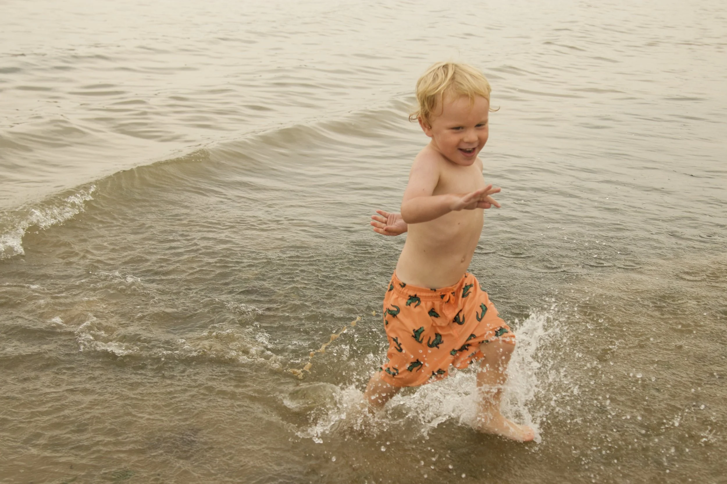 male child playing in waves at the beach on a UK holiday