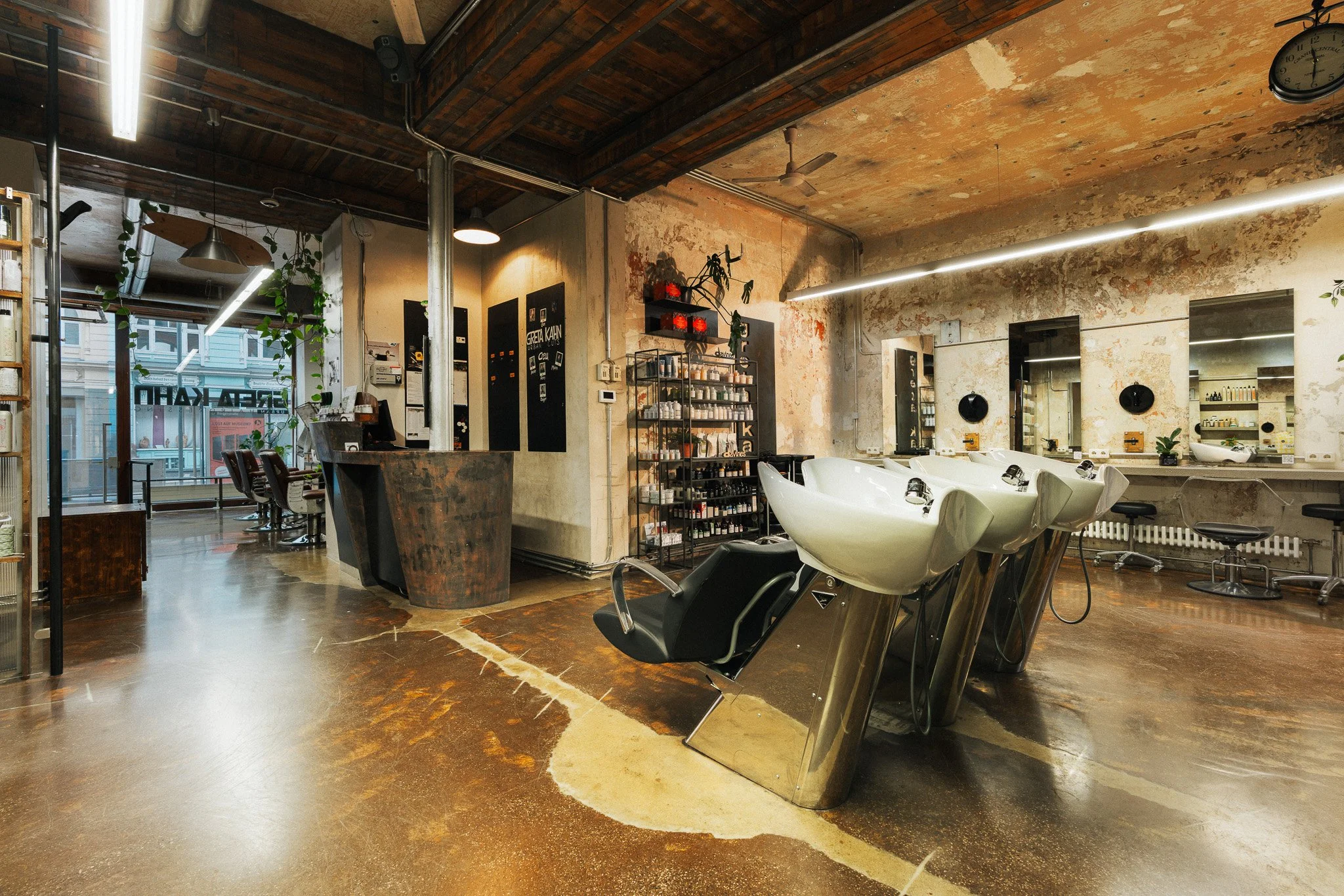 Friseursalon mit Waschbecken, Spiegel und Sitzplätzen, rustikaler Innenraum, große Fenster mit Blick nach draußen