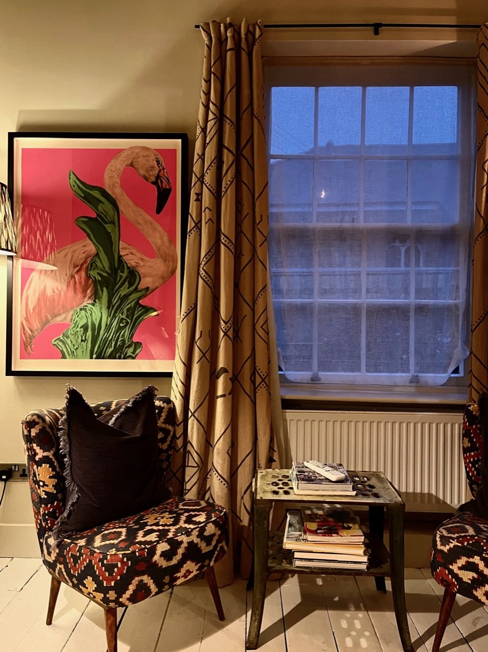 Bedroom lounging space with two chairs and art