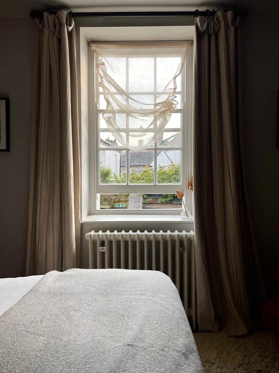 Window of room with curtains drawn and transparent blind.