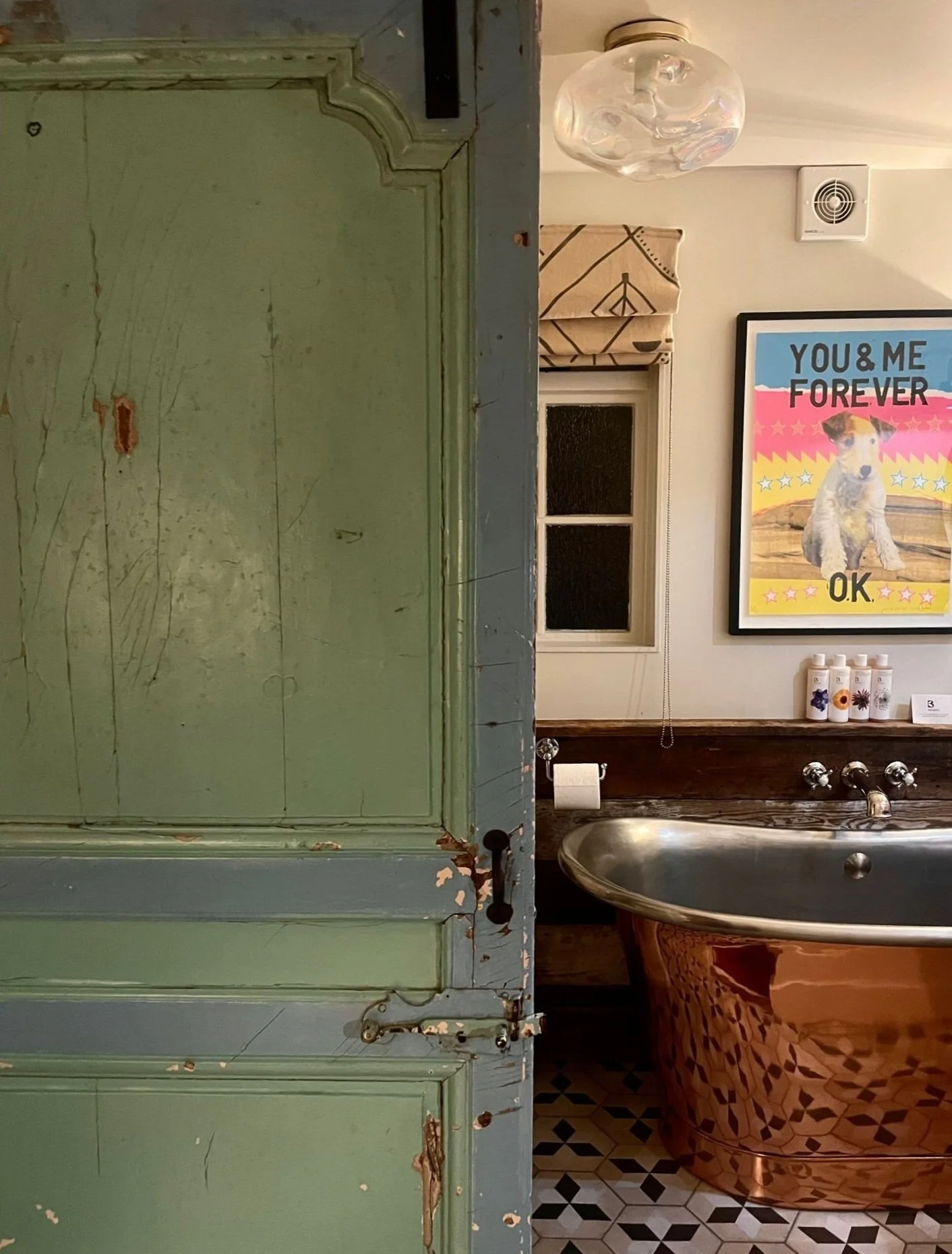 Wooden door half open to show copper bathtub