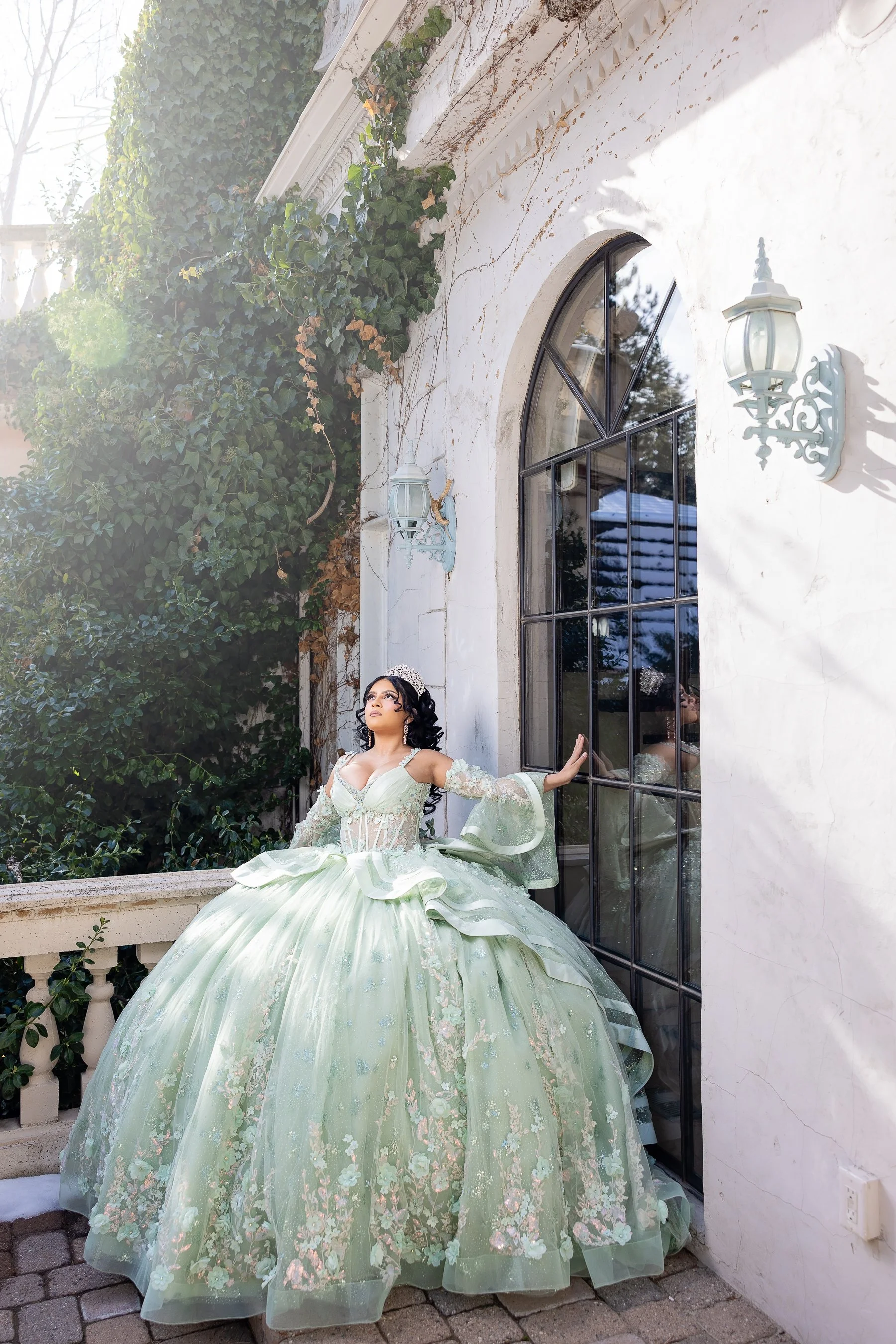 Elegant quinceañera portrait captured on the grand stone steps of La Caille’s château. The classic French architecture and soft natural light highlight the intricate details of the quinceañera gown.