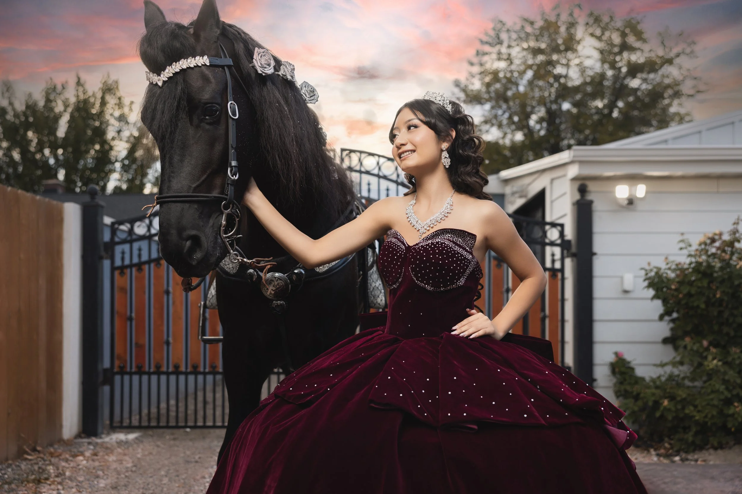 A Rancho La Gloria quinceañera photography session in Utah with a burgundy quince dress, black horse, and elegant outdoor portrait styling.