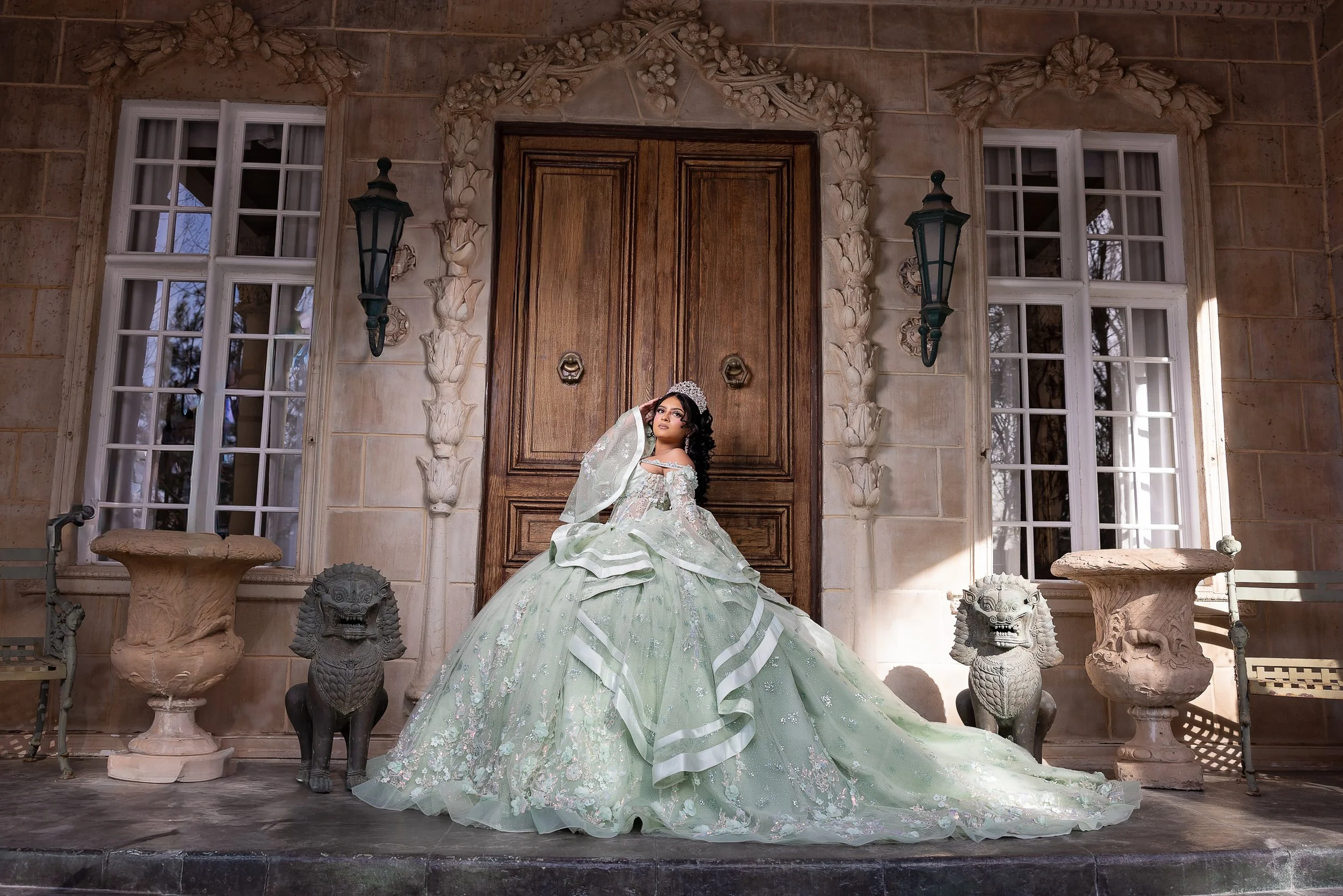 A regal quinceañera portrait framed by the historic wooden doors of La Caille’s château. The symmetrical architecture and sculpted stone details create a timeless, princess-inspired moment.