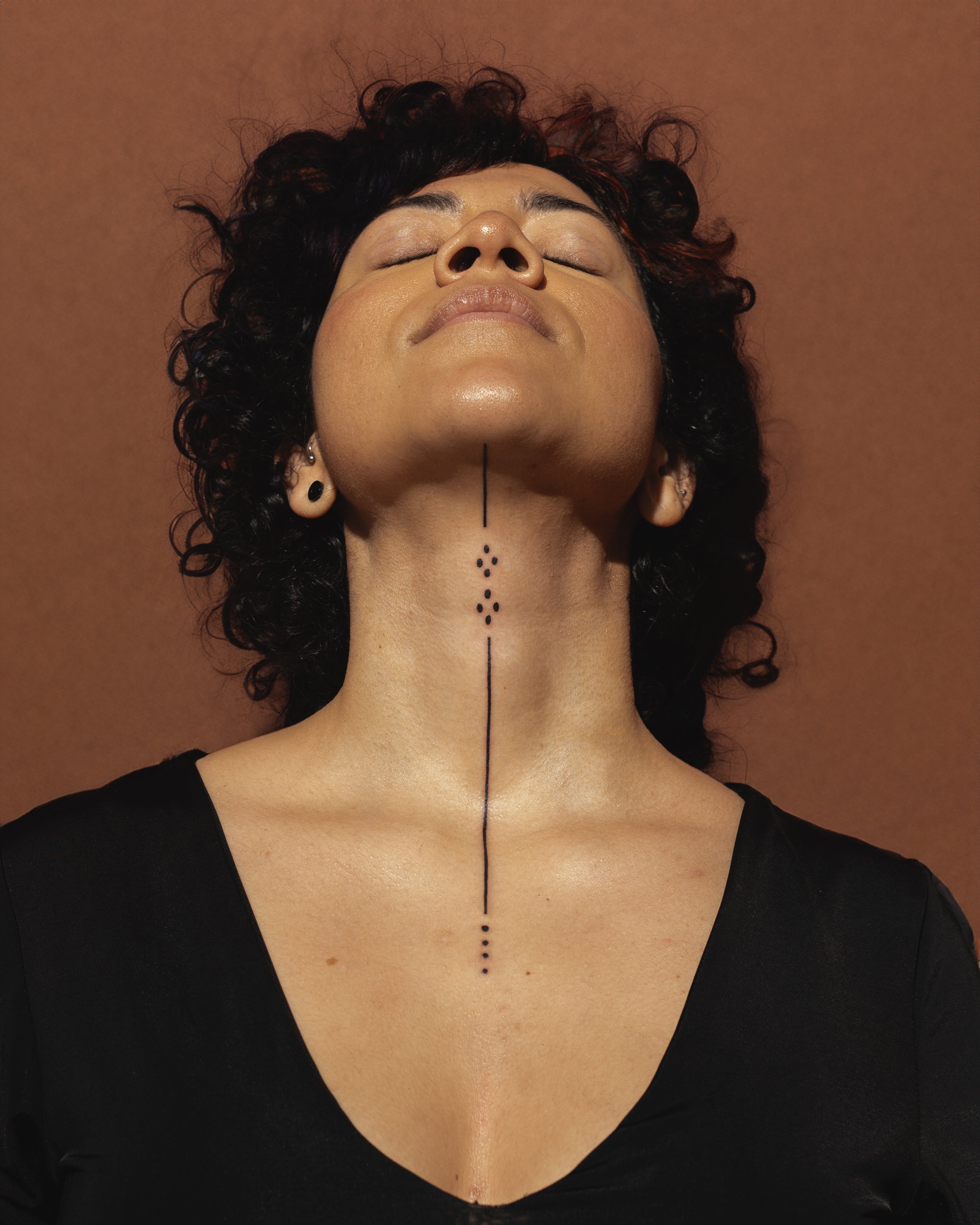 Minimal yet impactful neck tattoo by Toronto tattoo artist Alexandria Rising. Featuring fine lines, delicate dotwork, and precision detailing, this intentionally crafted piece activates the throat chakra.