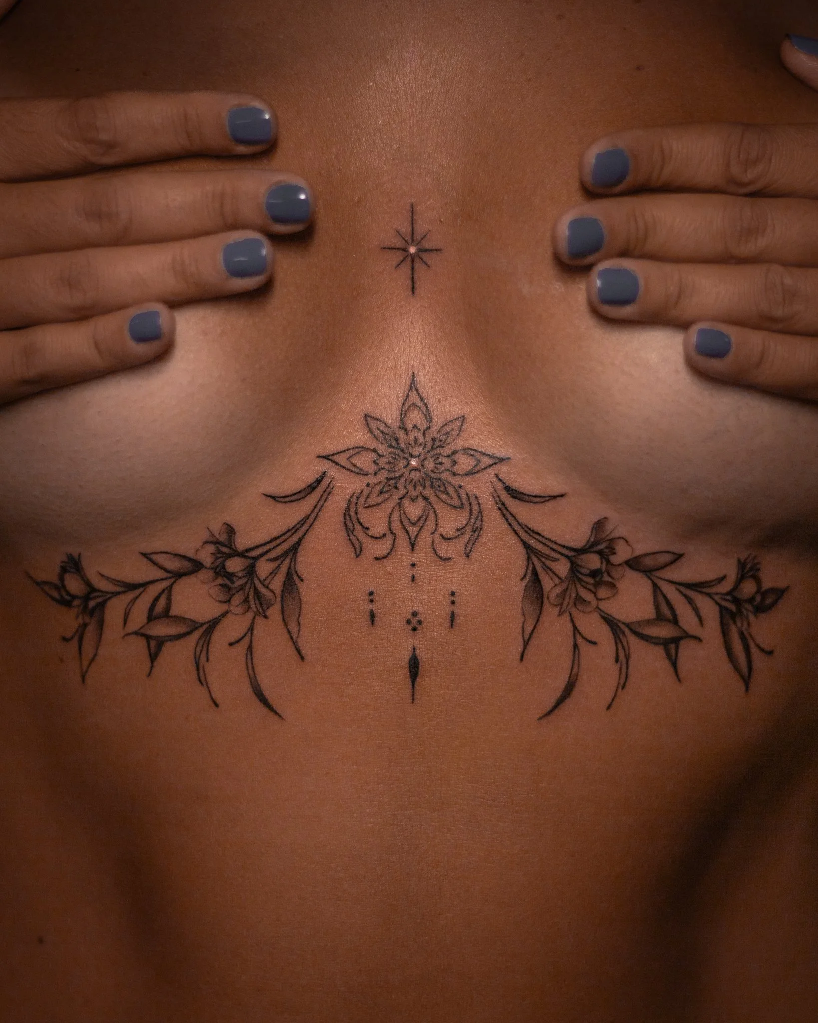 Feminine, soft floral-ornamental sternum tattoo by Toronto tattoo artist Alexandria Rising. A delicate, symmetrical design inspired by floral and sacred ornaments of the heart space, crafted to make the wearer’s heart radiate.