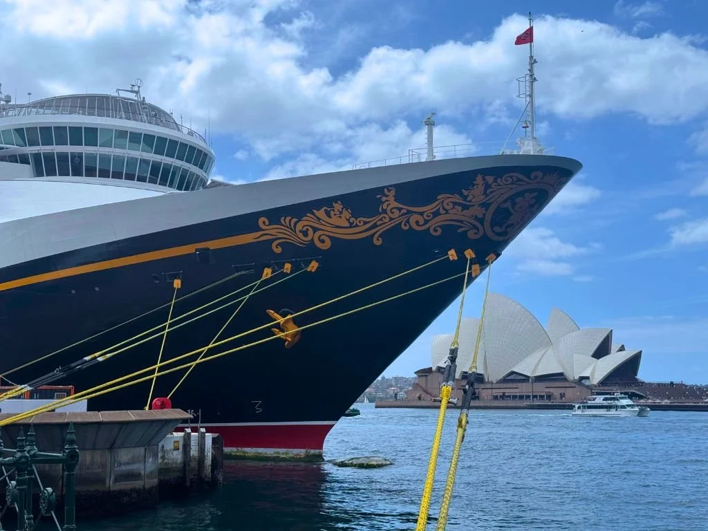 The Disney Wonder cruise ship in front of the Sydney Opera House.