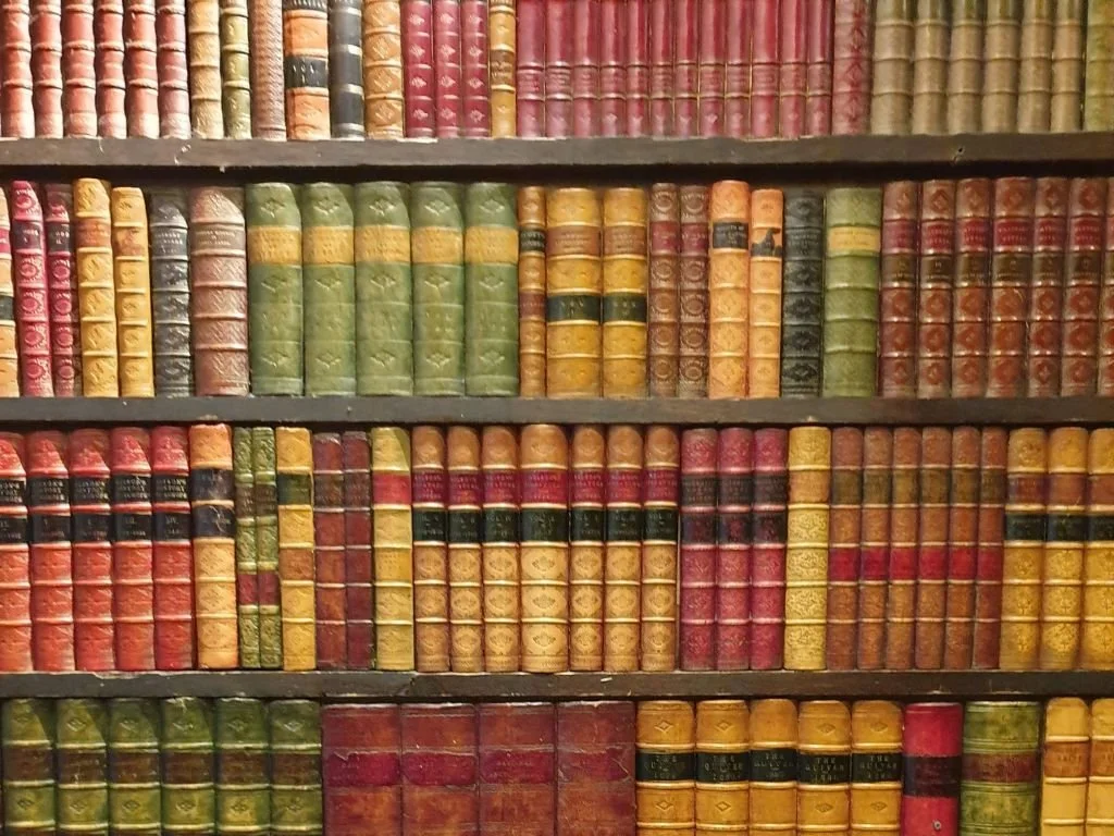 Rows of old and new books on wooden shelves inside a London bookshop.