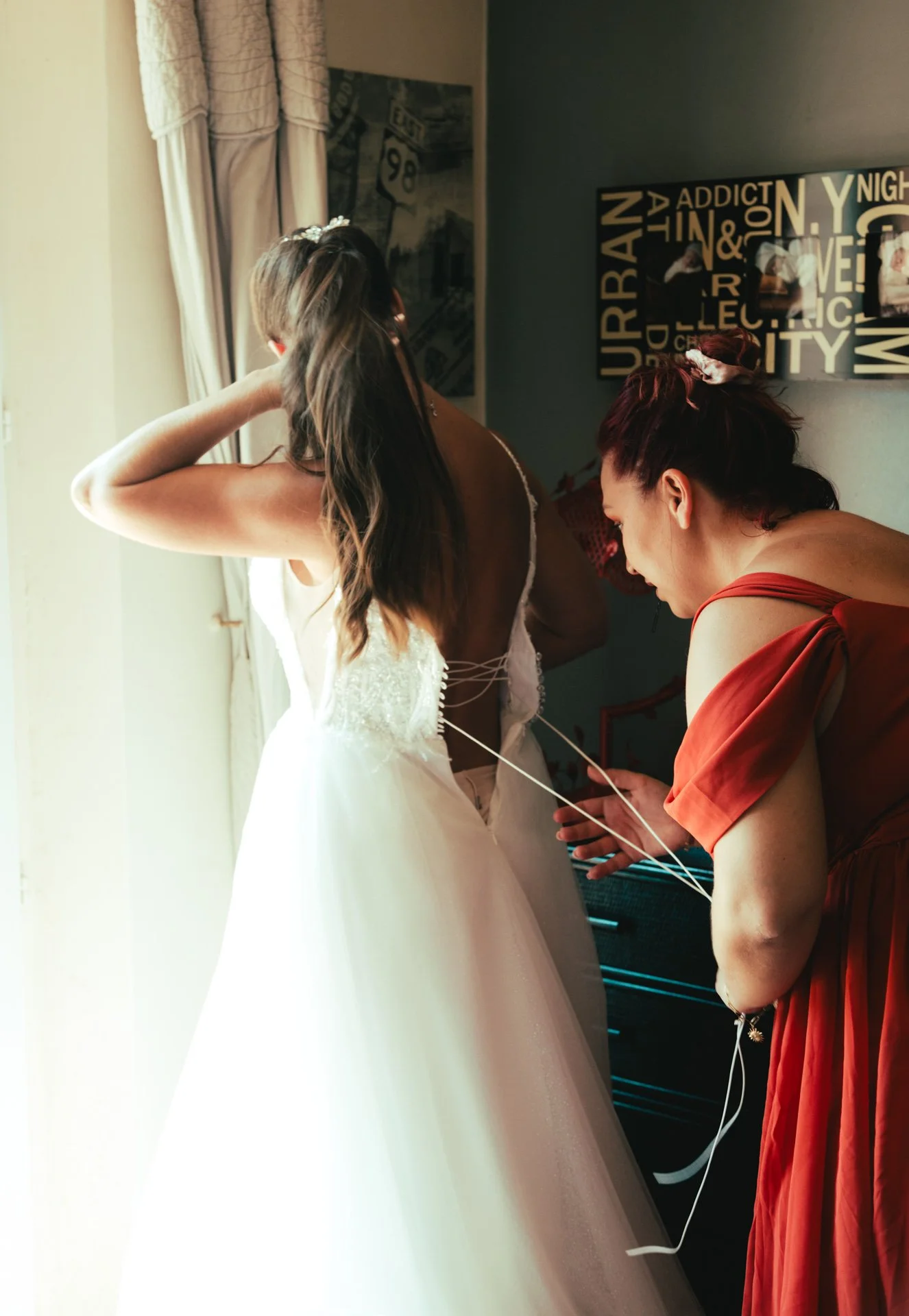 habillage de la mariée avec l'aide de sa témoin, photographe mariage saint-tropez