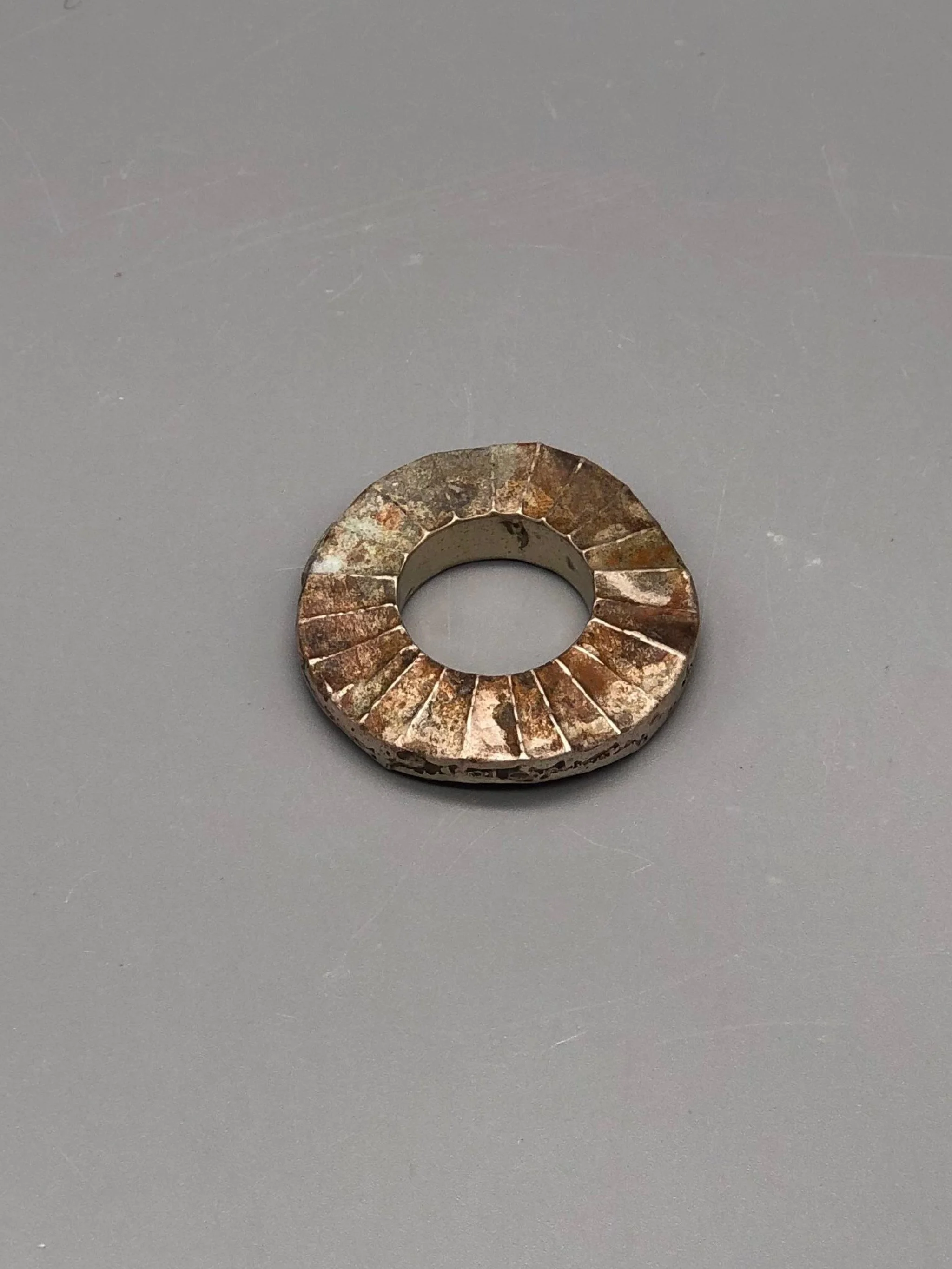Mangàni Sole ring in oxidized 925 sterling silver with irregular circular form and radial textured surface.