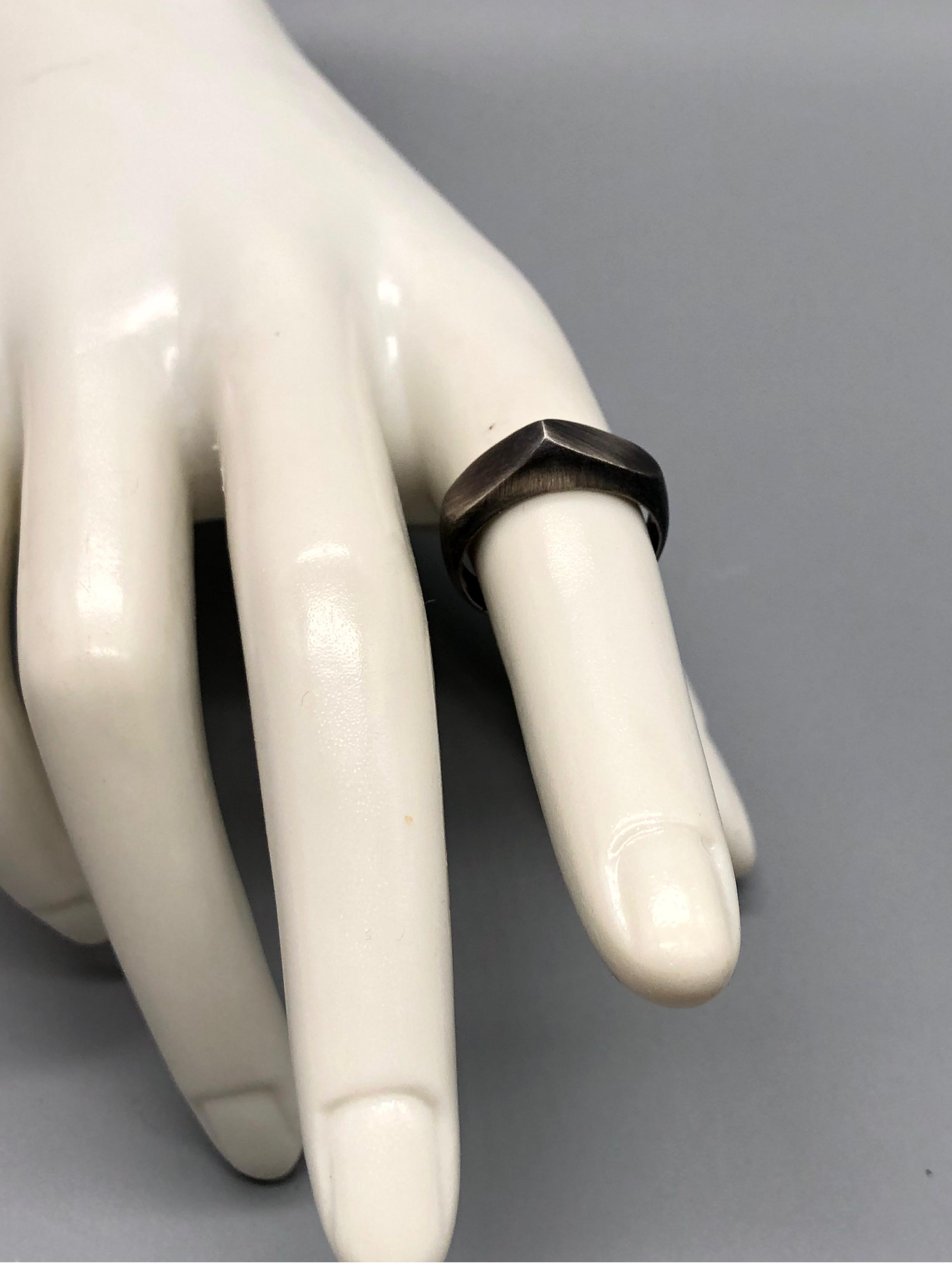 Anello Cuspide Crepundia in argento 925 brunito, con fascia geometrica, superfici sfaccettate e finitura scura satinata\.  *Crepundia Cuspide ring in oxidized sterling silver 925, featuring a geometri
