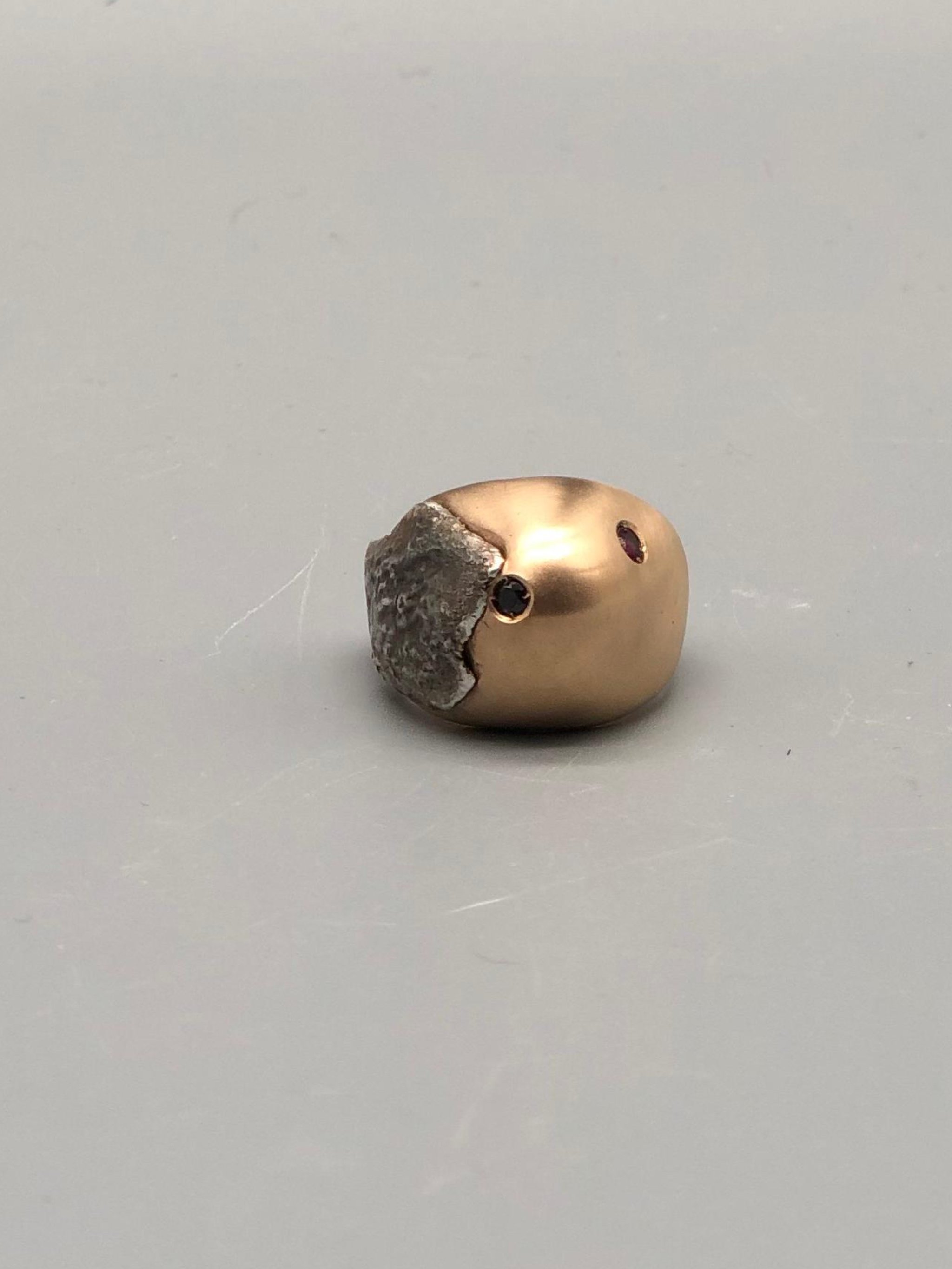 Padma Hill ring in rose bronze with raw silver application, garnet and black zircon. Sculptural contemporary handmade ring available at Crepundia Gioielli Bologna.