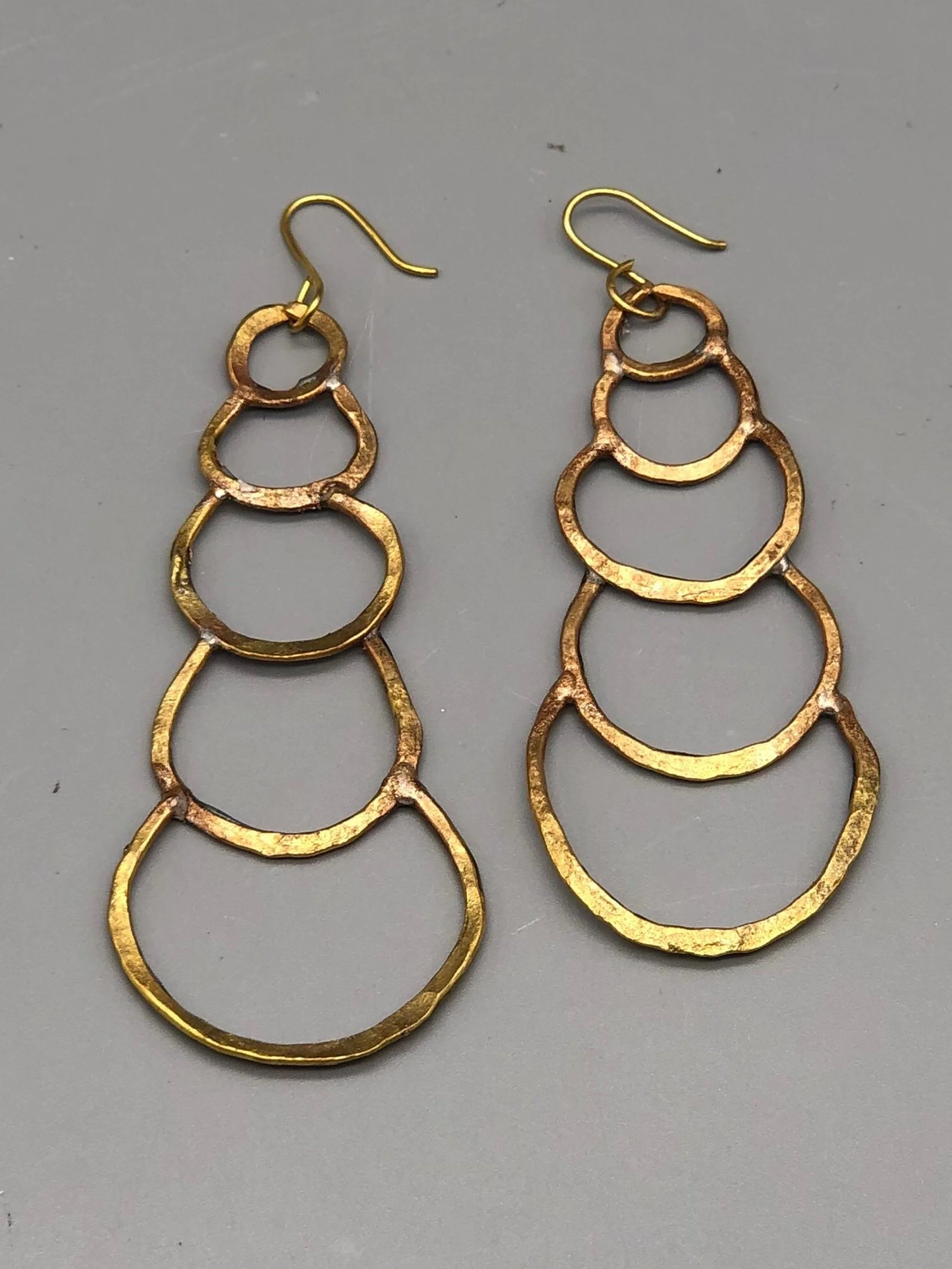 Orecchini Outline Drops di Claudia Cuzzeri in ottone opaco con forme circolari irregolari.