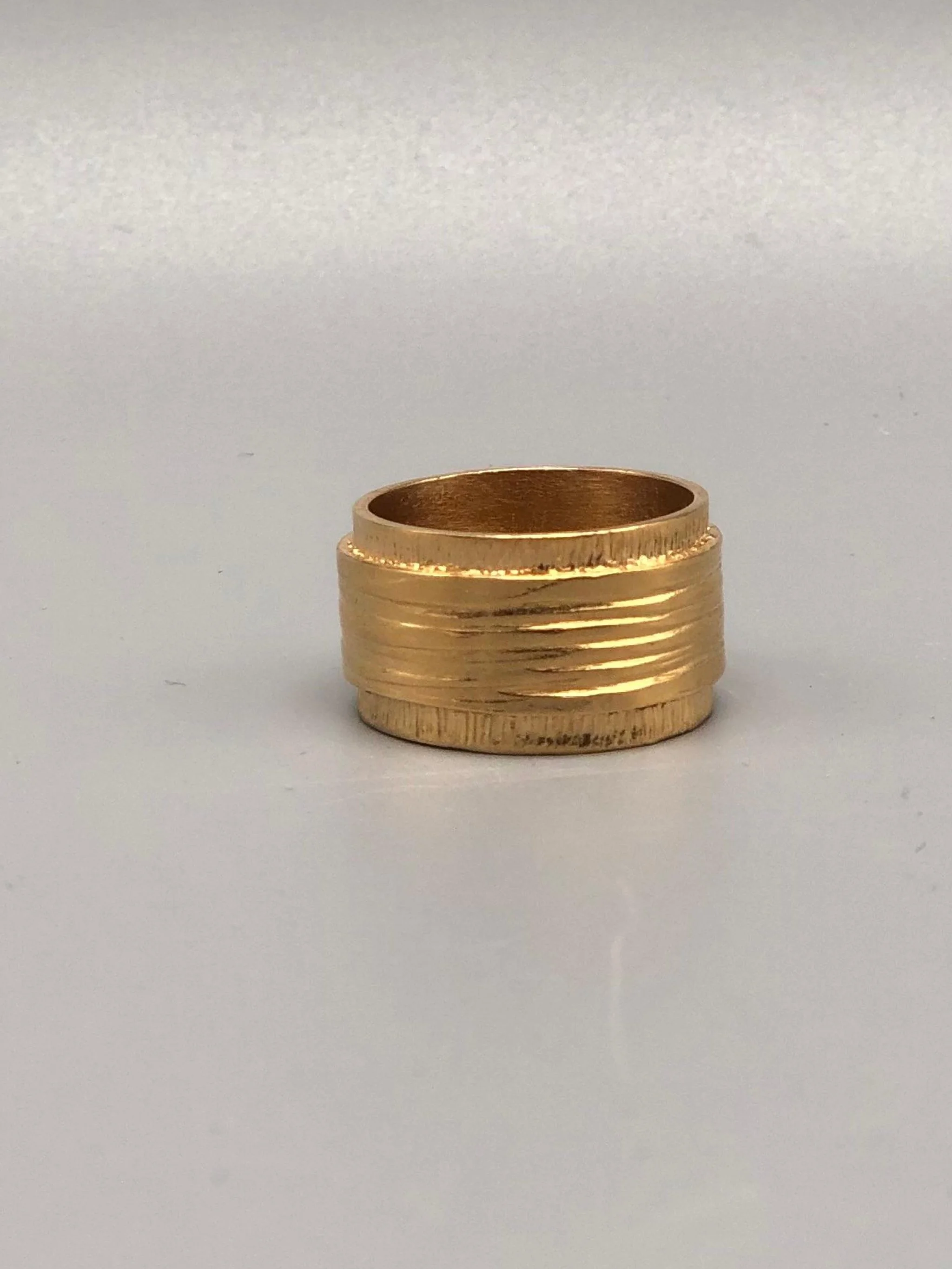 Anello fascia in bronzo placcato oro giallo 18 carati inciso, design scultoreo, Gabriel Reinoso per Crepundia Gioielli Bologna