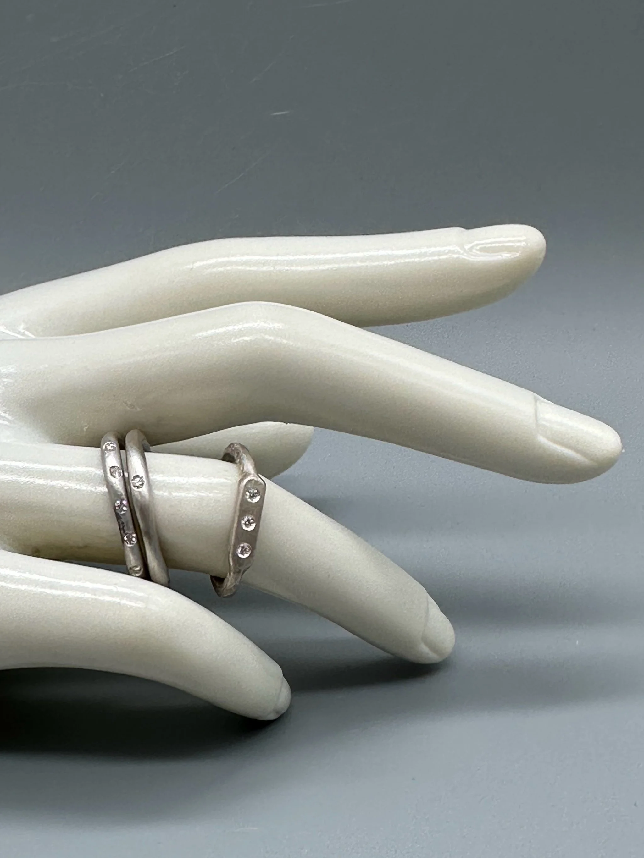 Interplay di Crepundia Gioielli, composizione di tre anelli in argento Full Wave, Wave e Flat 3, con diamanti per un totale di 0,12 ct. Interplay by Crepundia Gioielli, a set of three contemporary sil