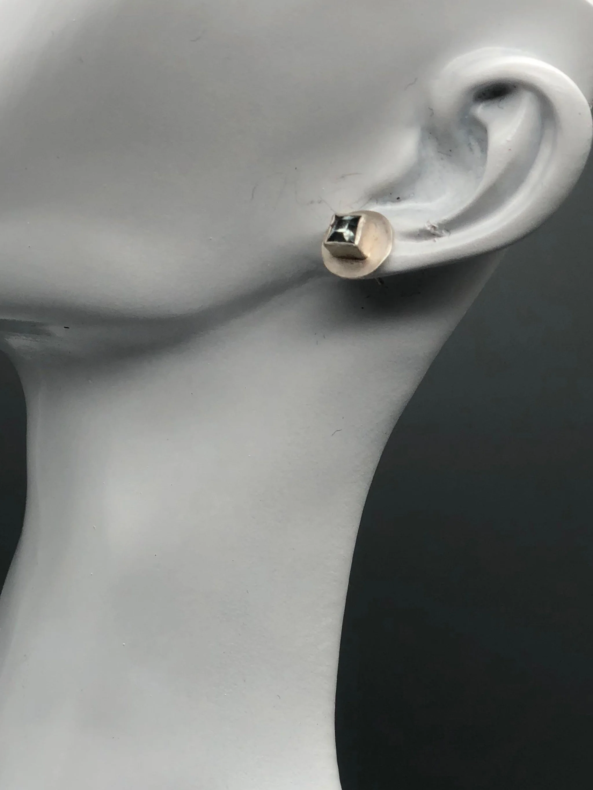 Monologue satin silver earrings with square aquamarine and raised geometric setting, Crepundia Gioielli Bologna.